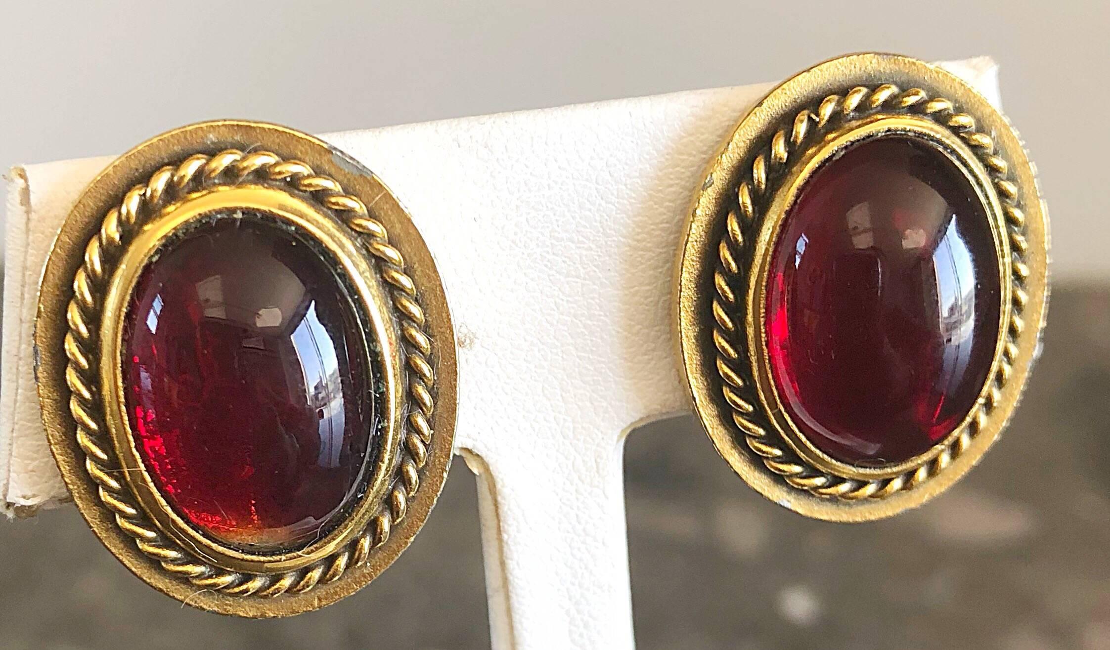 Classic large vintage YVES SAINT LAURENT ruby red gripoix and gold round domed clip-on earrings. Each earring features a large round ruby red Gripoix glass dome. Gold edges have a rope textured backing. Can easily be dressed up or down. Great with