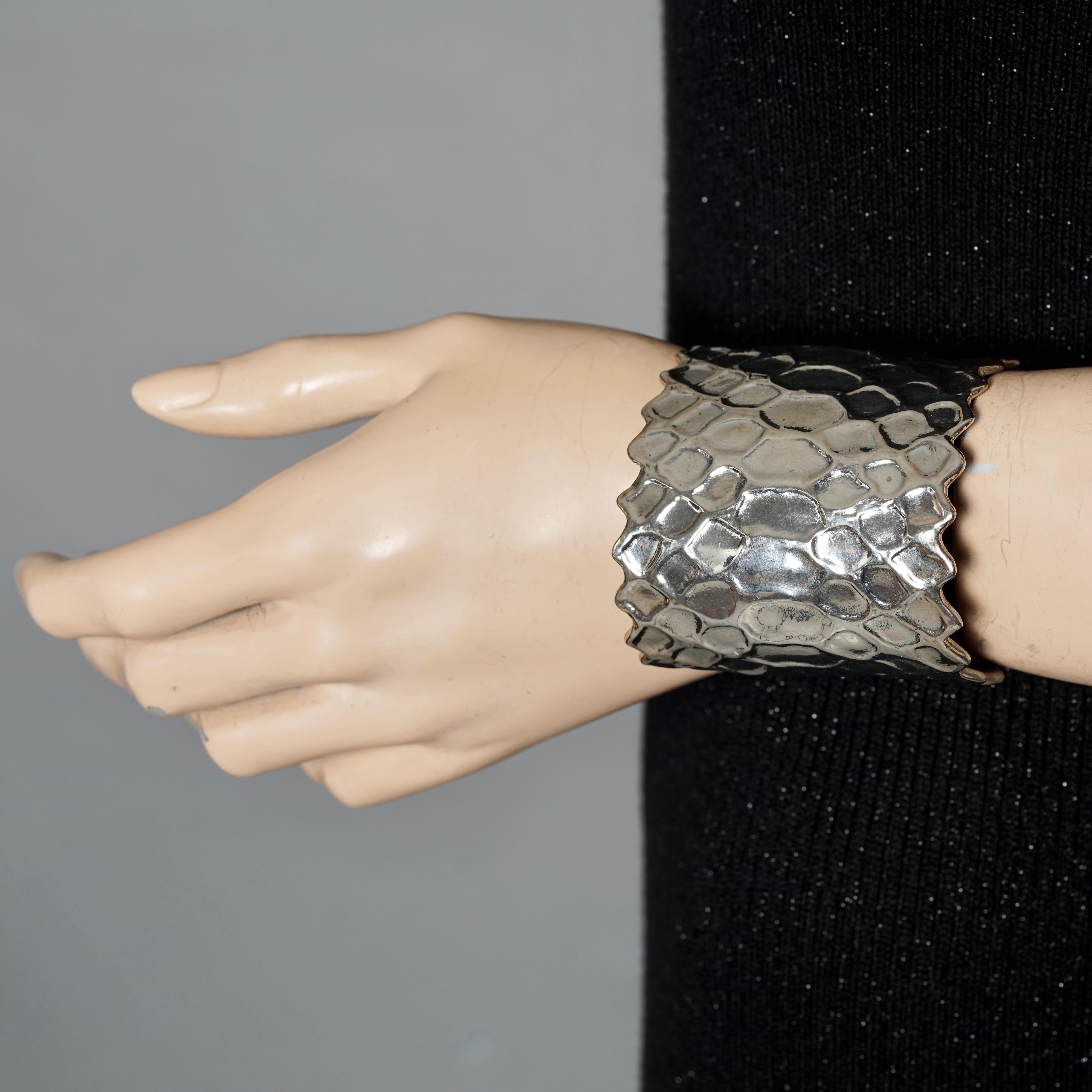 Vintage YVES SAINT LAURENT Ysl Snake Pattern Silver Cuff Bracelet

Measurements:
Height: 2.44 inches (6.2 cm)
Circumference: 6.55 inches (16.64 cm) opening included

Features:
- 100% Authentic YVES SAINT LAURENT.
- Intricate snake skin pattern