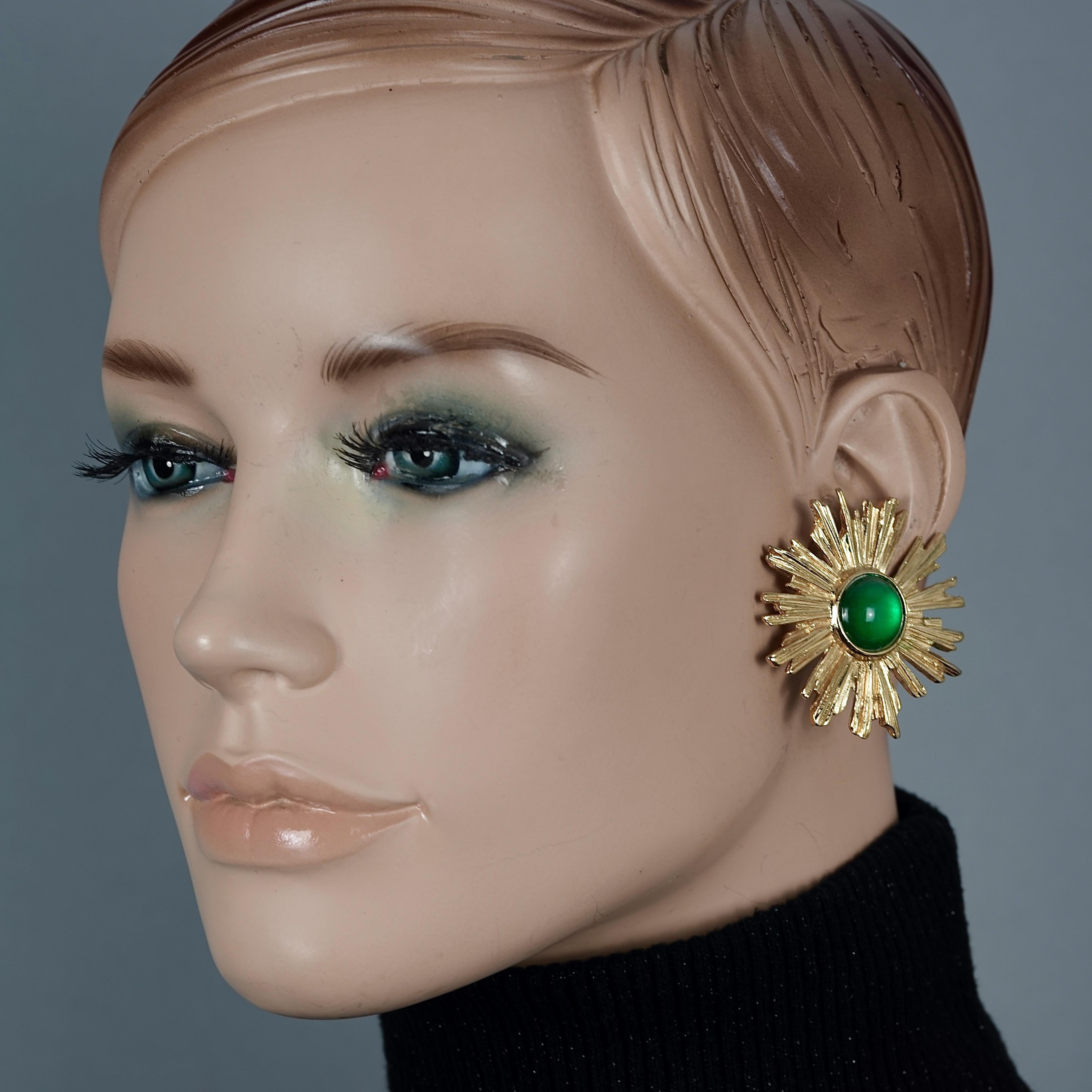 Vintage YVES SAINT LAURENT Ysl Sunburst Emerald Stone Earrings

Measurements:
Height: 1.81 inches (4.6 cm)
Width: 1.73 inches (4.4 cm)
Weight: 18 grams

Features:
- 100% Authentic YVES SAINT LAURENT.
- Fax emerald stone cabochon at the centre with