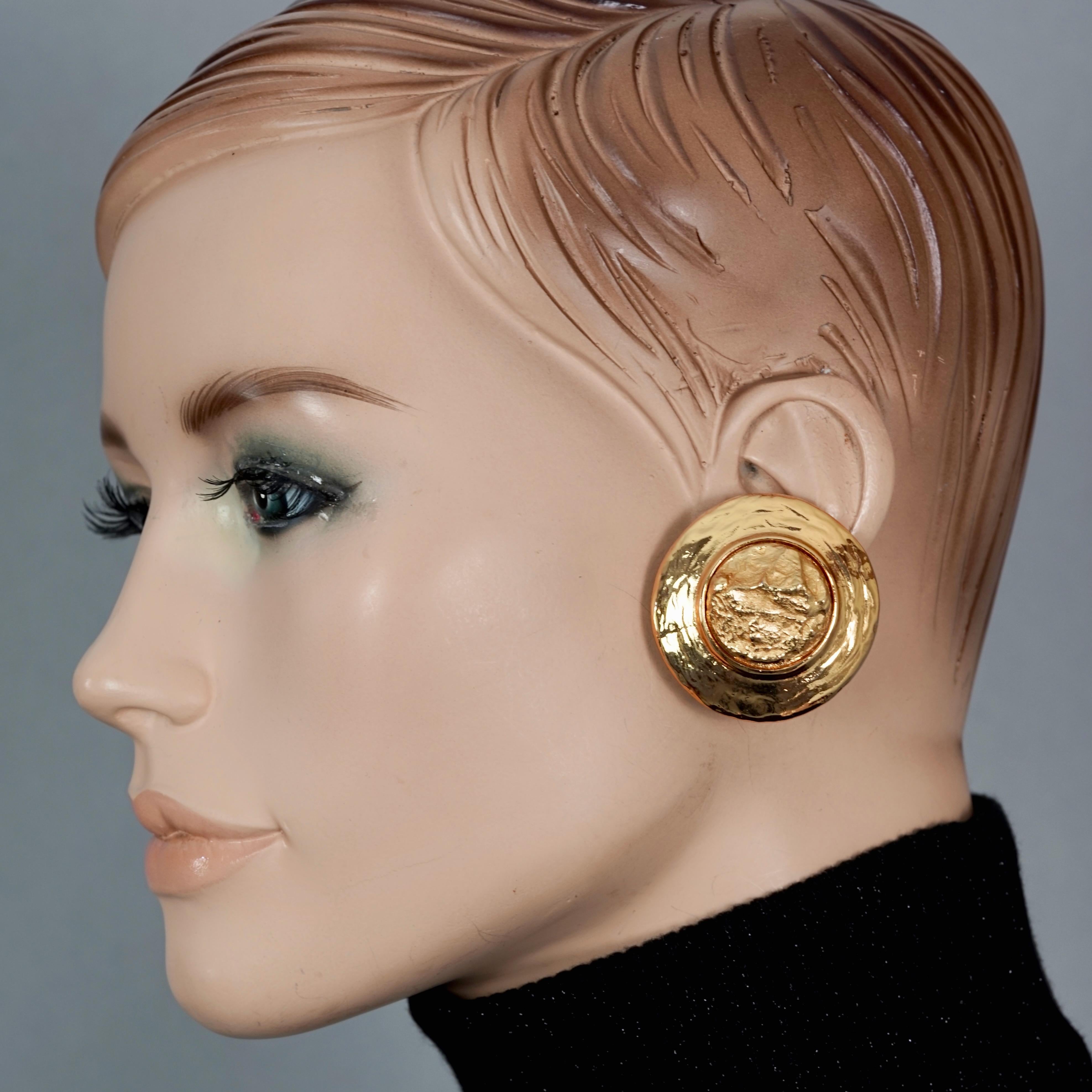 Vintage YVES SAINT LAURENT Ysl Textured Gold Round Earrings

Measurements:
Height: 1.61 inches (4.1 cm)
Width: 1.61 inches (4.1 cm)
Weight per Earring: 23 grams

Features:
- 100% Authentic YVES SAINT LAURENT.
- Round textured disc earrings.
- Clip