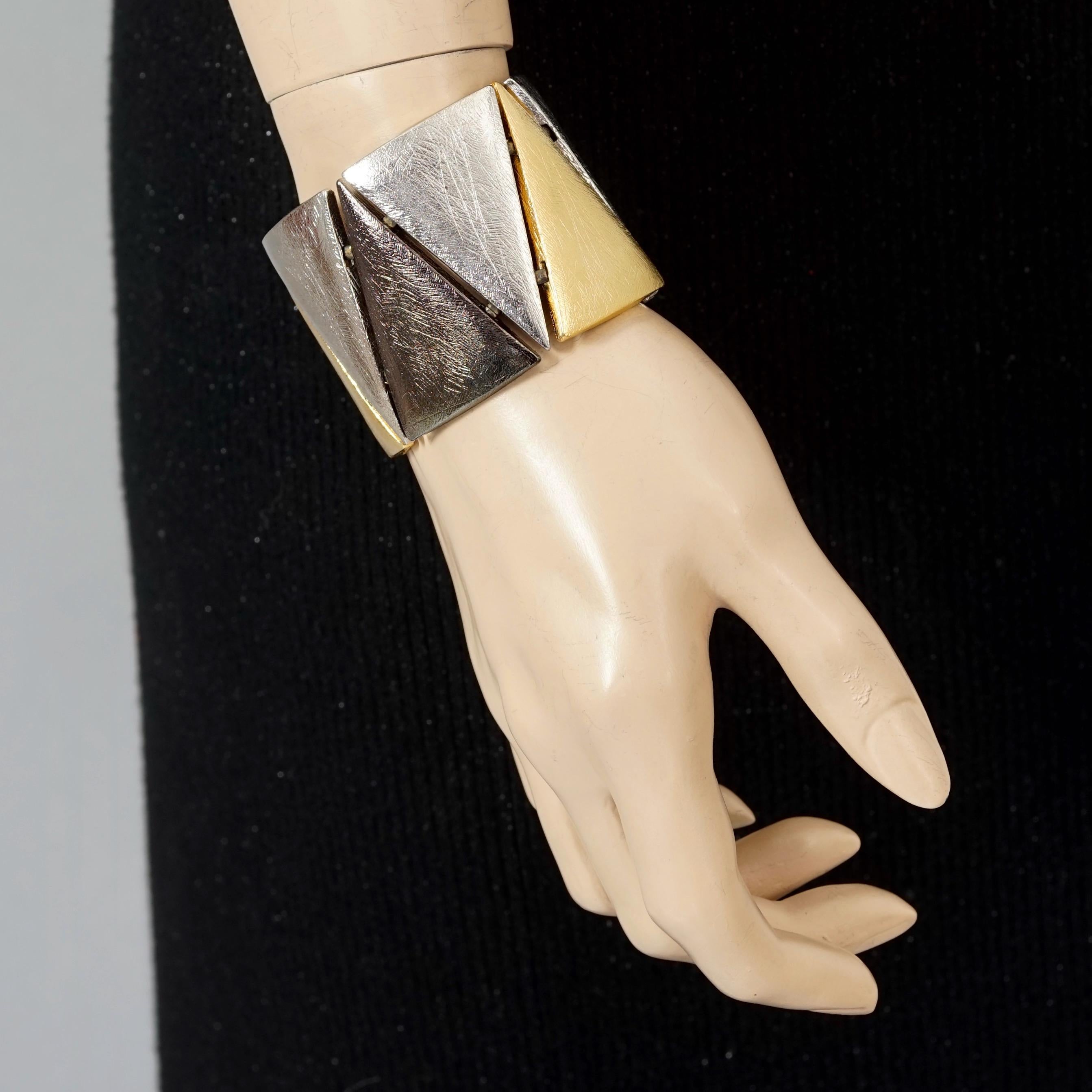 Vintage YVES SAINT LAURENT Ysl Triangle Link Tricolor Cuff Bracelet

Measurements:
Height: 1.96 inches (5 cm)
Wearable Length: 6.88 inches (17.5 cm)

Features:
- 100% Authentic YVES SAINT LAURENT.
- Triangle link cuff bracelet.
- Gold, silver and