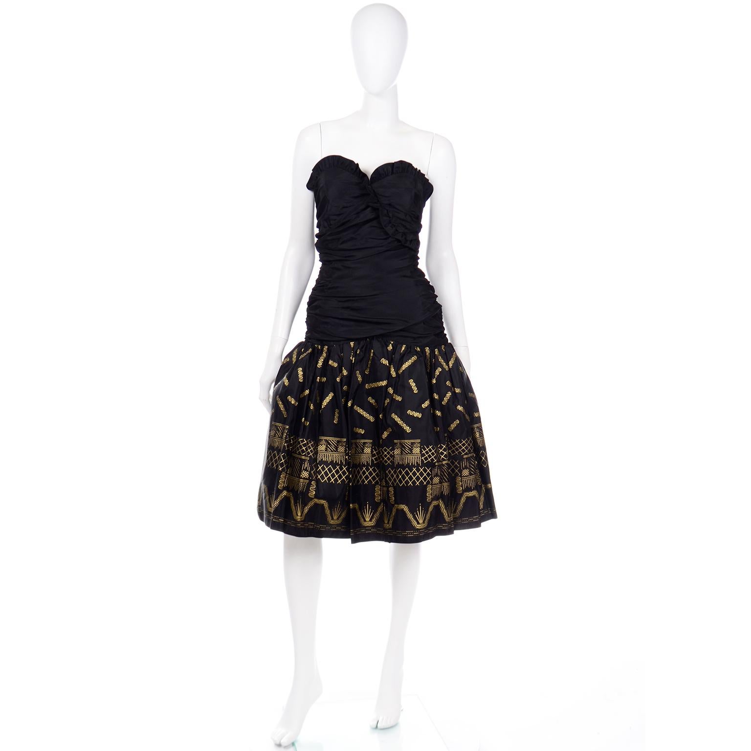 This is a fun vintage Zandra Rhodes evening dress from the 1980's in black taffeta with fully ruched sides and back, a ruffled sweetheart neckline and a drop waist. We love the gorgeous Zandra Rhodes signature gold stencil design on the tulle lined