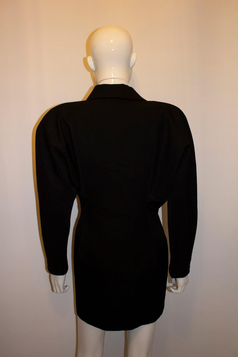 Ein schickes Vintage-Mantelkleid von Zandra Rhodes  mit wunderbarem Schneiderhandwerk. Das Kleid von Zandra Rhodes 11 hat einen Verschluss mit drei Knöpfen  vorne mit wunderschönen Knöpfen, Schulterpads und attraktivem Futter. 100 % Wolle. Größe 10