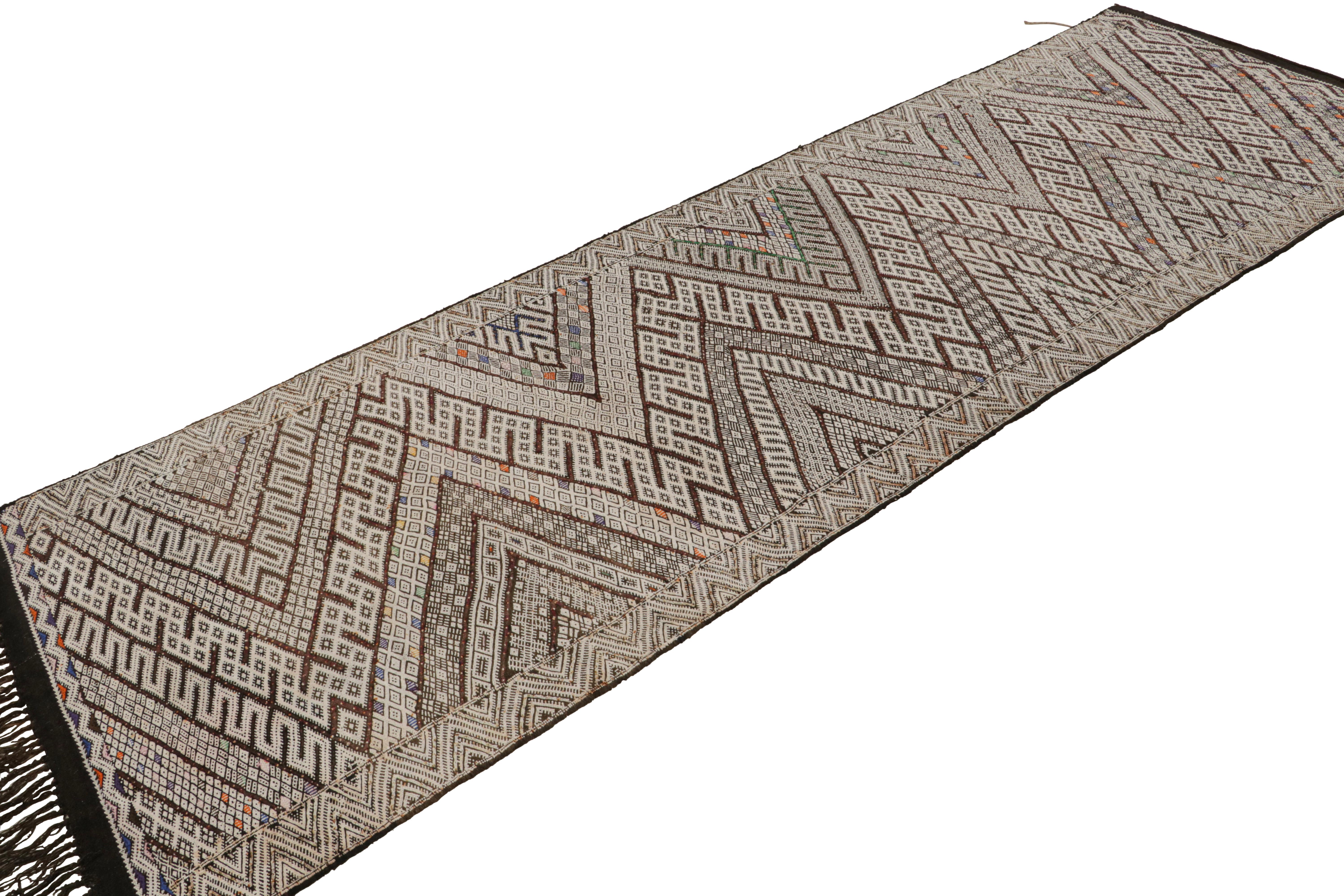 Tissé à la main en laine, ce tapis marocain vintage 3x11 Rug & Kilim de Zayane serait originaire de la chaîne de montagnes du Moyen Atlas au Maroc. Il porte le nom de la même tribu, un peuple nomade particulièrement Revere, profondément attaché à