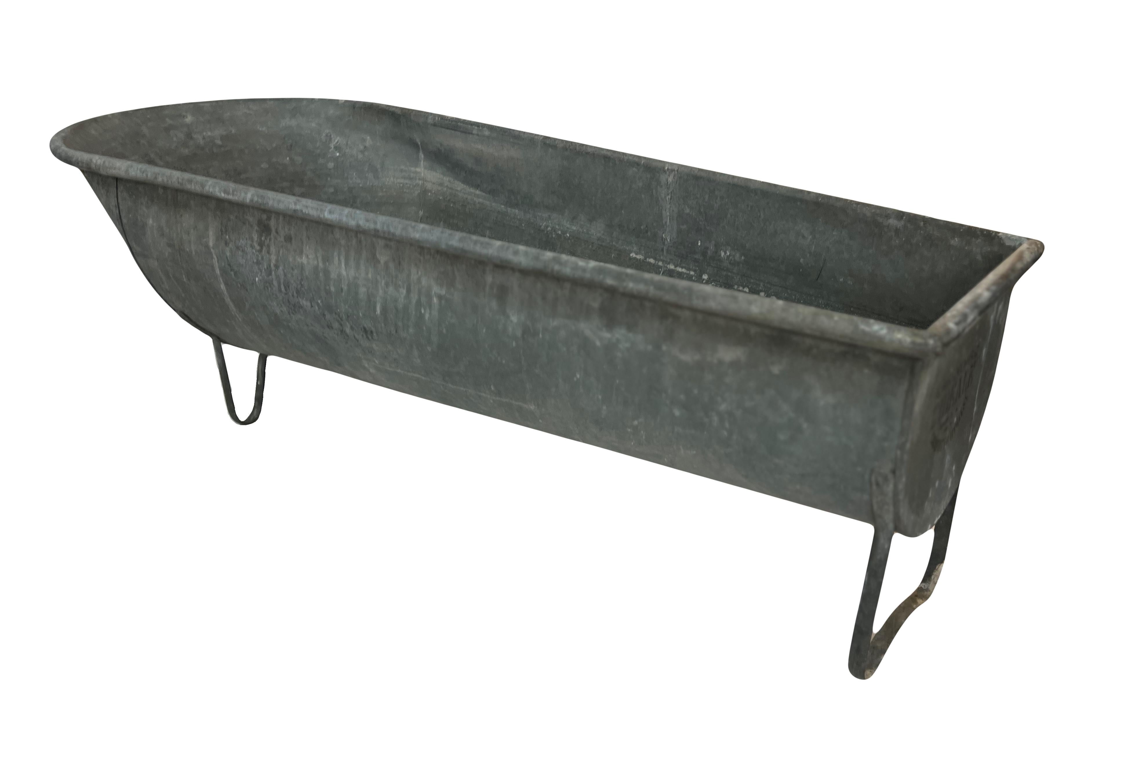 Diese wunderschöne Zinkbadewanne im Vintage-Stil, die auf drei festen Füßen steht, trägt eine schwarze französische Aufschrift: 