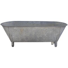 Vieille baignoire en zinc avec pieds en fer