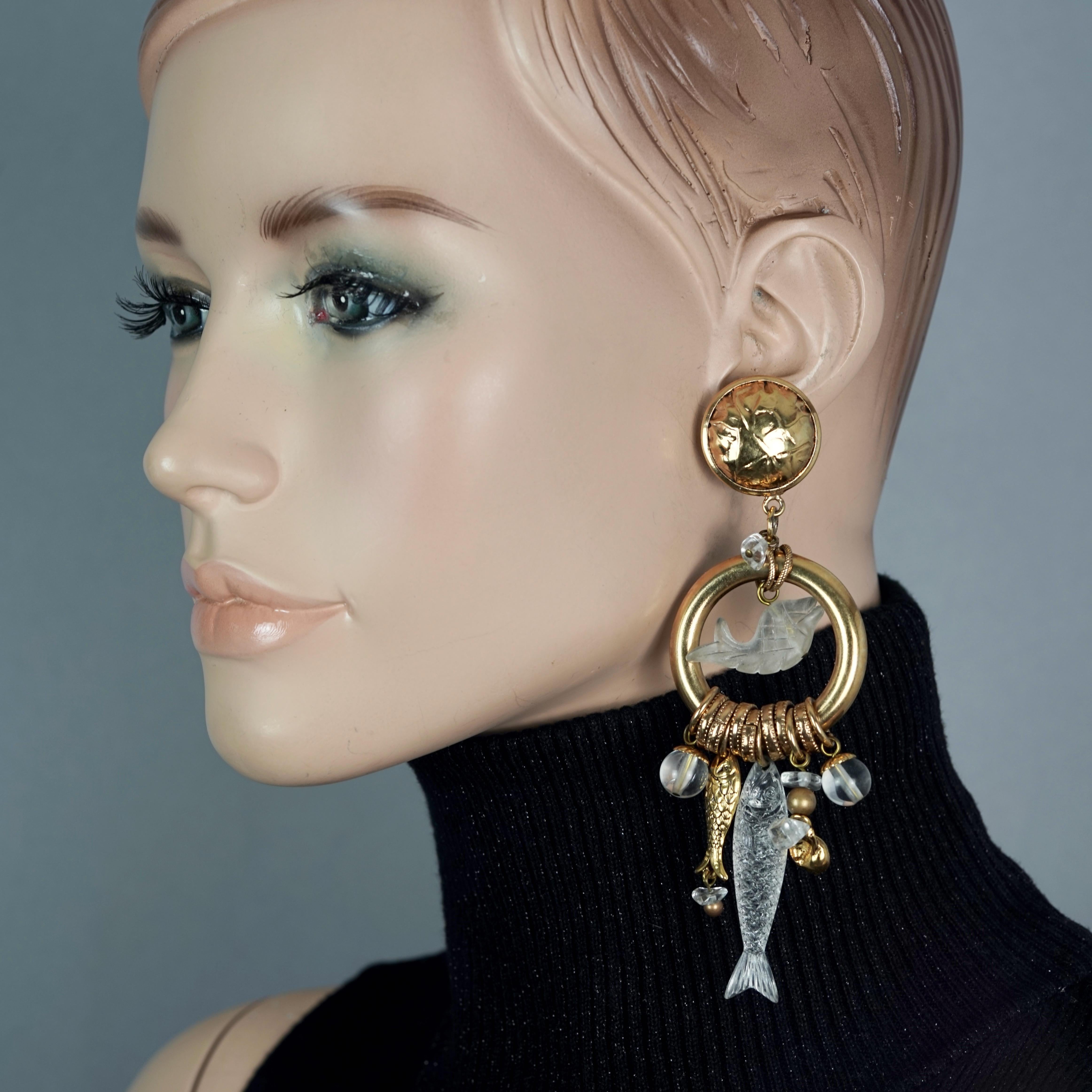 Vintage ZOE COSTE Lucite Fish Sea Shells Charm Dangling Earrings

Measurements:
Height: 4.80 inches (12.2 cm)
Width: 1.65 inches (4.2 cm)
Weight: 32 grams

Features:
- 100% Authentic ZOE COSTE.
- Long Earrings with Lucite fish and gilt sea shell