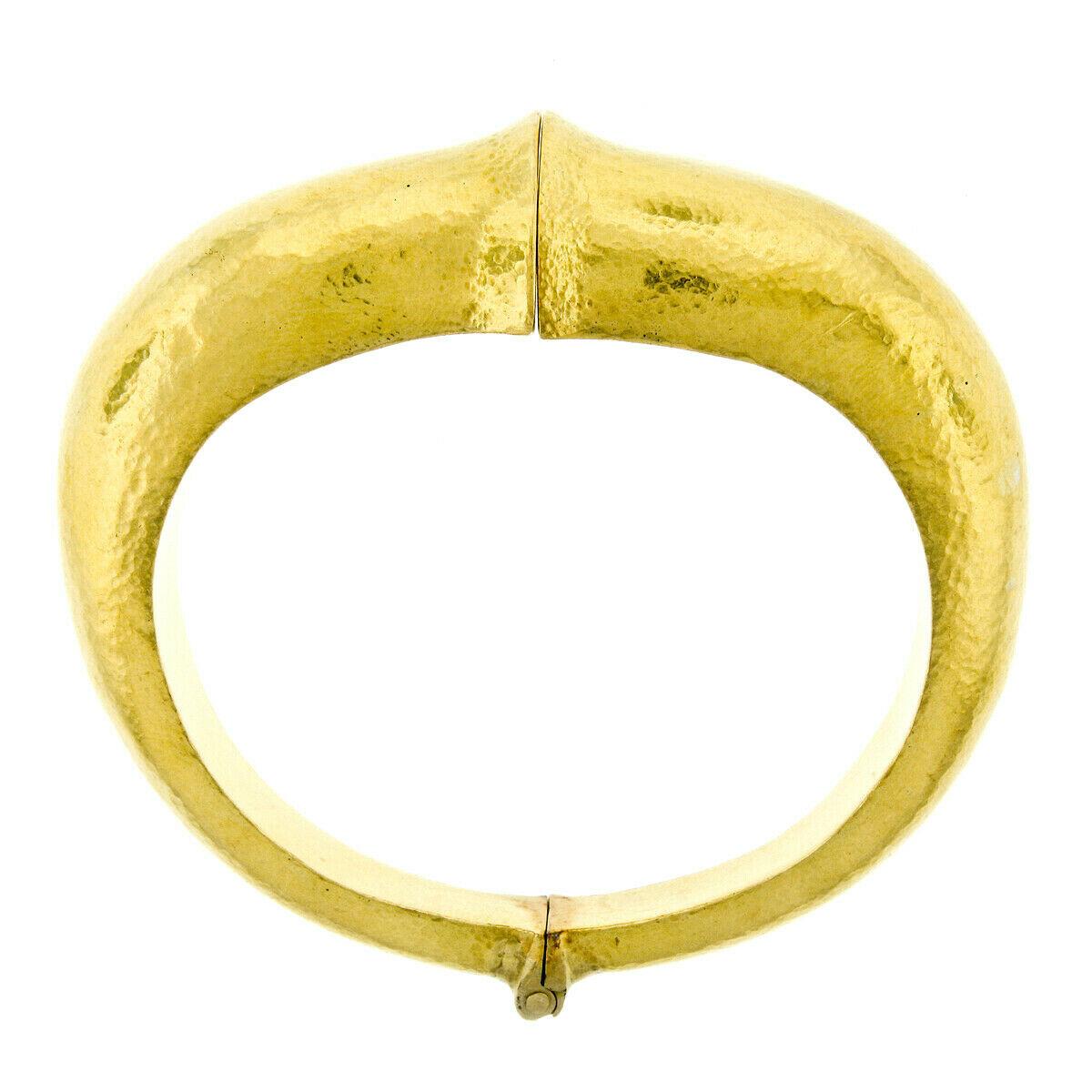 This large and very well-made hinged bangle bracelet was crafted by Zolotas in solid 22k yellow gold. The bracelet has a simple flowing design and features Zolotas's fine hammered finish. Enjoy!

Material: Solid 22k Yellow Gold
Weight: 88.4