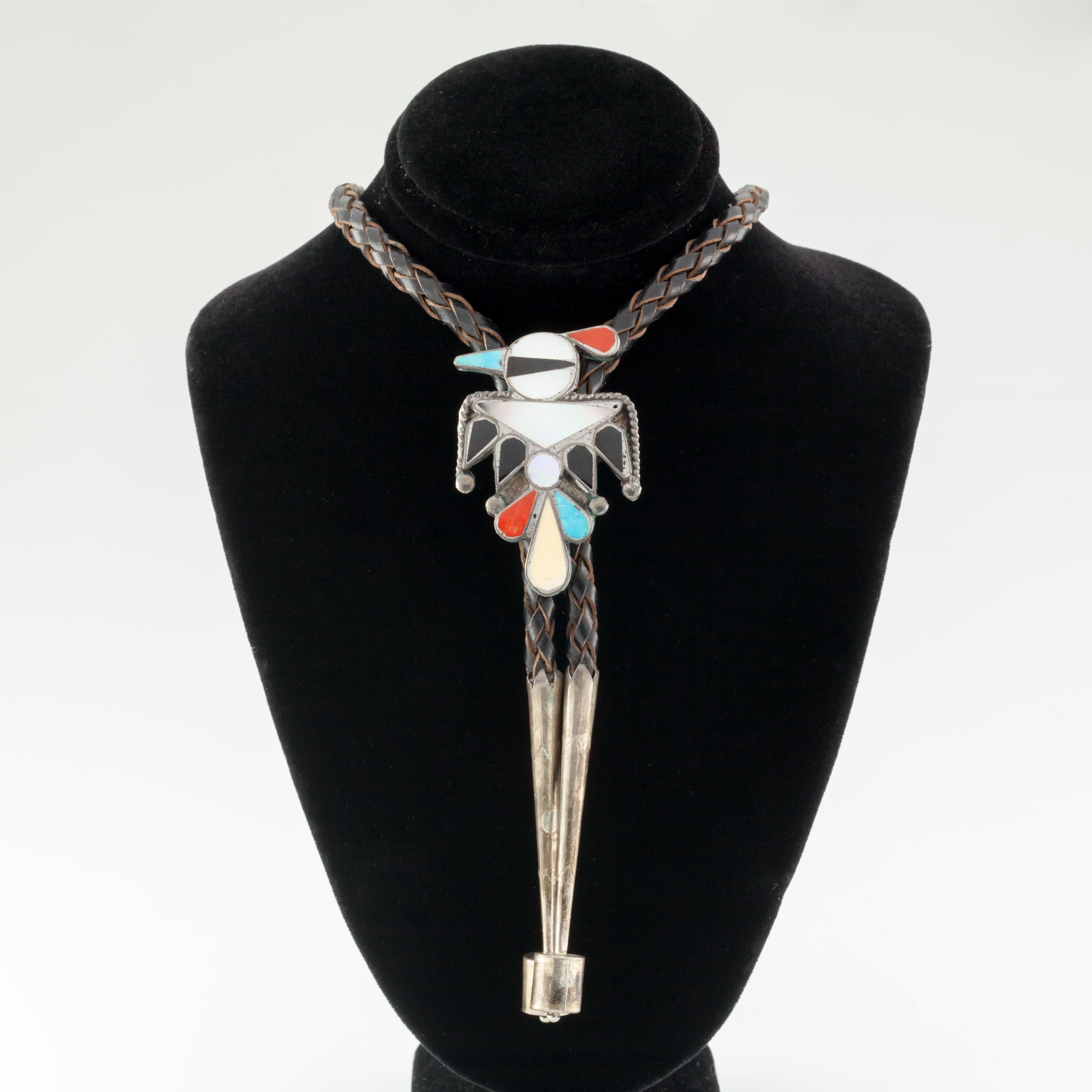 Bellissima Bolo con intarsio di uccelli e cravatta in pelle marrone con inserti in argento. 
Intarsio naturale con pietre incastonate a forma di uccello   
Lunghezza e larghezza della Bolo = 46 mm X 31,5 mm
Massa totale con pelle = 25.4