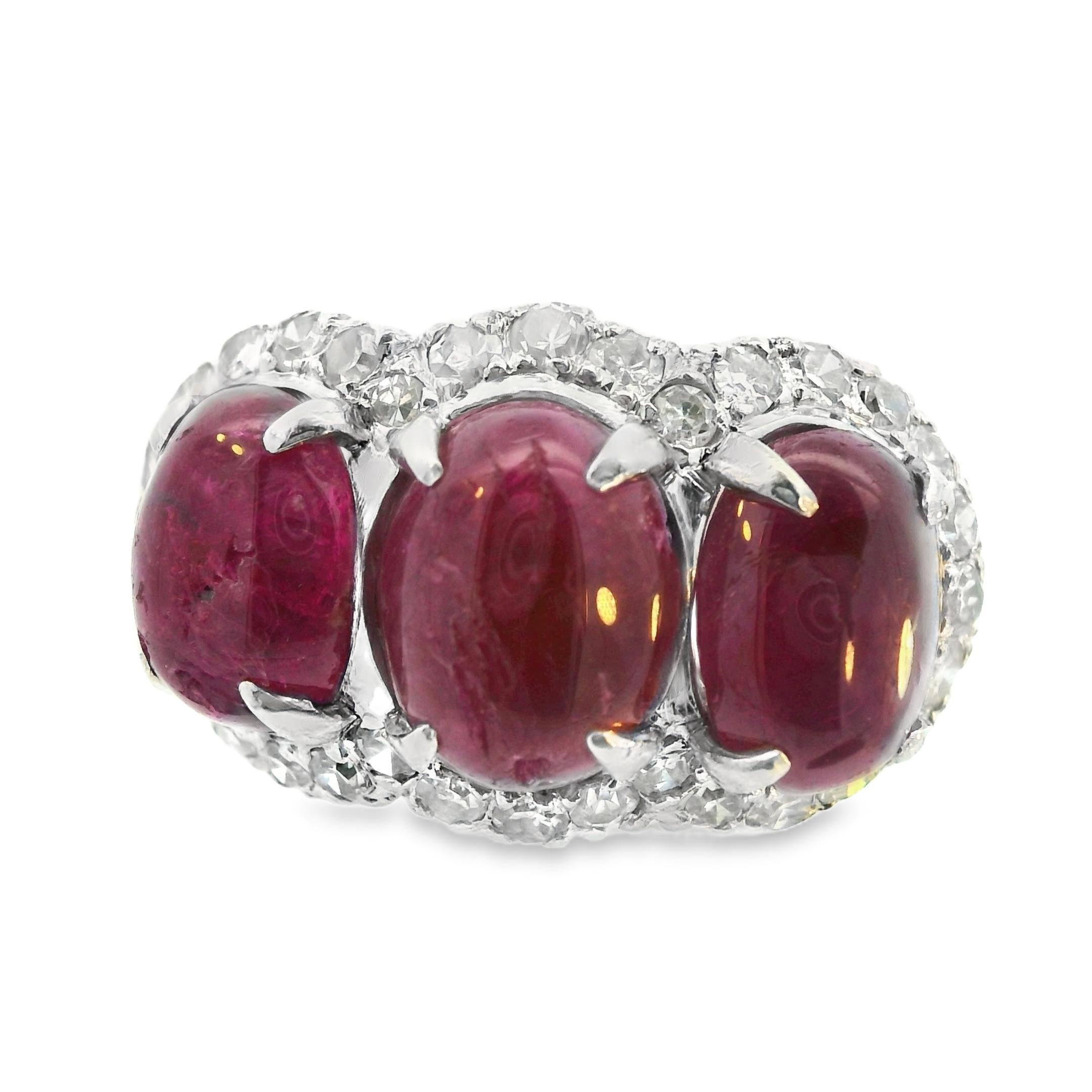This beautiful ring is like no other! It features a traditional 3 stone design with three large, oval cabachon, natural corundum rubies in a gorgeous talon setting. Surrounding the 3 oval cabochon rubies is a wall of bright white, round cut,