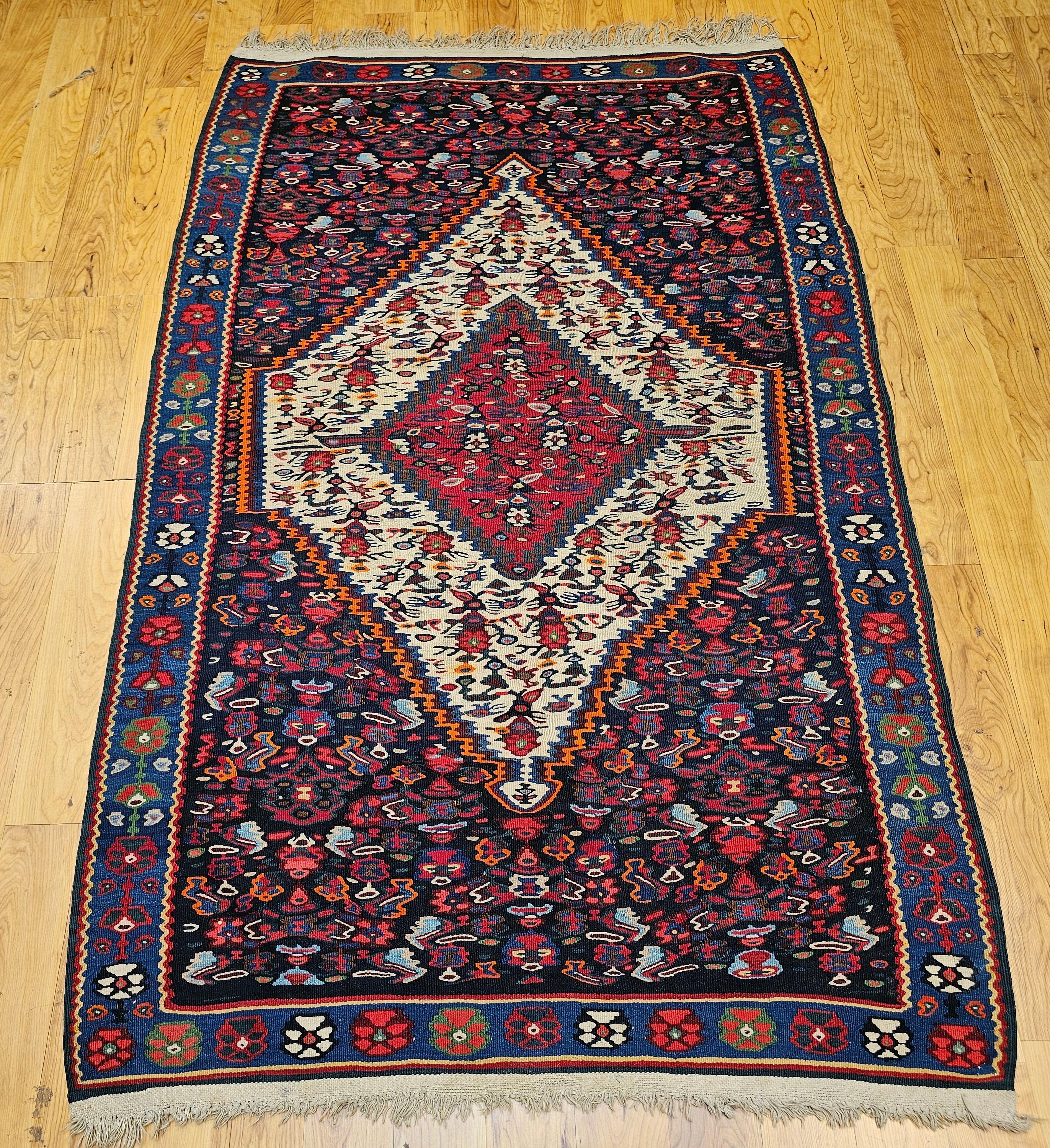 A masterful example of Persian textile artistry, this mid-20th century Senneh kilim area rug showcases the refined weaving tradition of Kurdish villages in Western Persia. Finely handwoven in the classic flatweave kilim technique, the rug features a