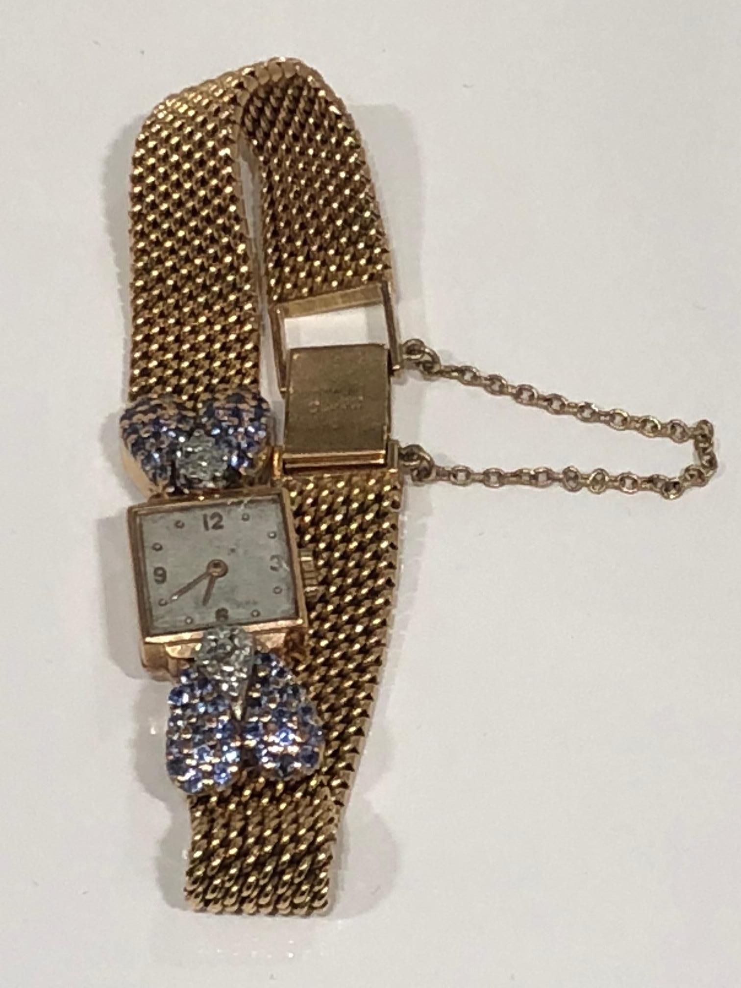 Vintage 18k gold ladies wrist watch, square face with gold weave chain band with diamond and ceylon sapphire encrusted details, clasp closure with security chain, stamped and numbered. circa 1940
Wrist band measures 7