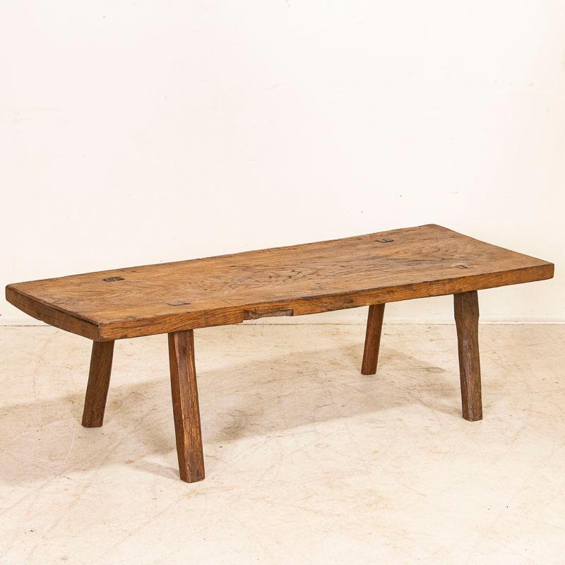The dark, aged patina is inviting in this old butchers work table that now serves as a coffee table. Every scrape, deep gouge, stain and crack acquired with well over 100 years of use have loaded it with character. Whether you are looking for an