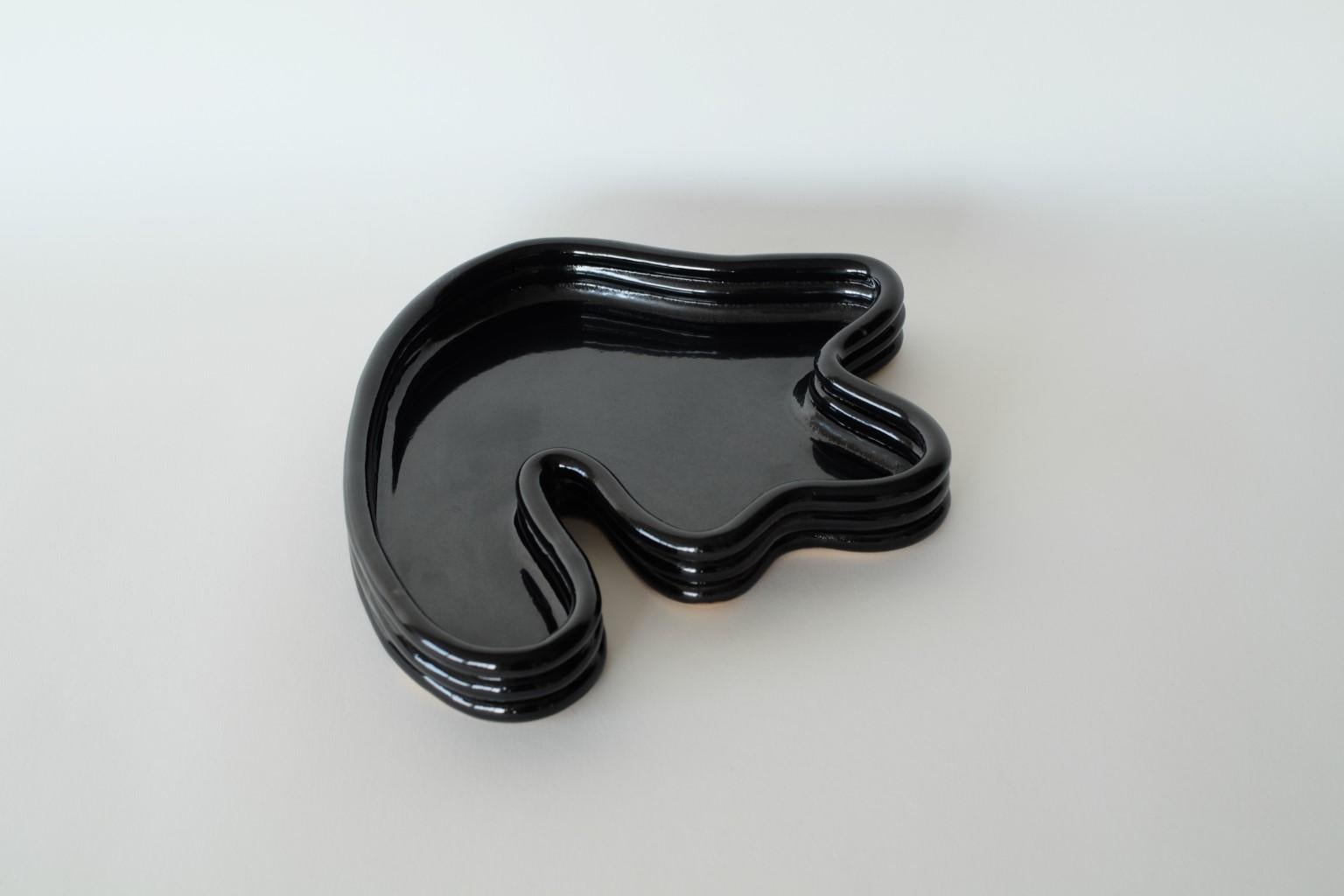 Vinyl black Lali small vide poche by Sophie Parachey
Dimensions: W 28 x D 24 x H 3.5 cm
Materials: Stoneware.

Inspired by extended stays in Central America, Sophie Parachey’s work questions transformation, the antagonism between the ancestral