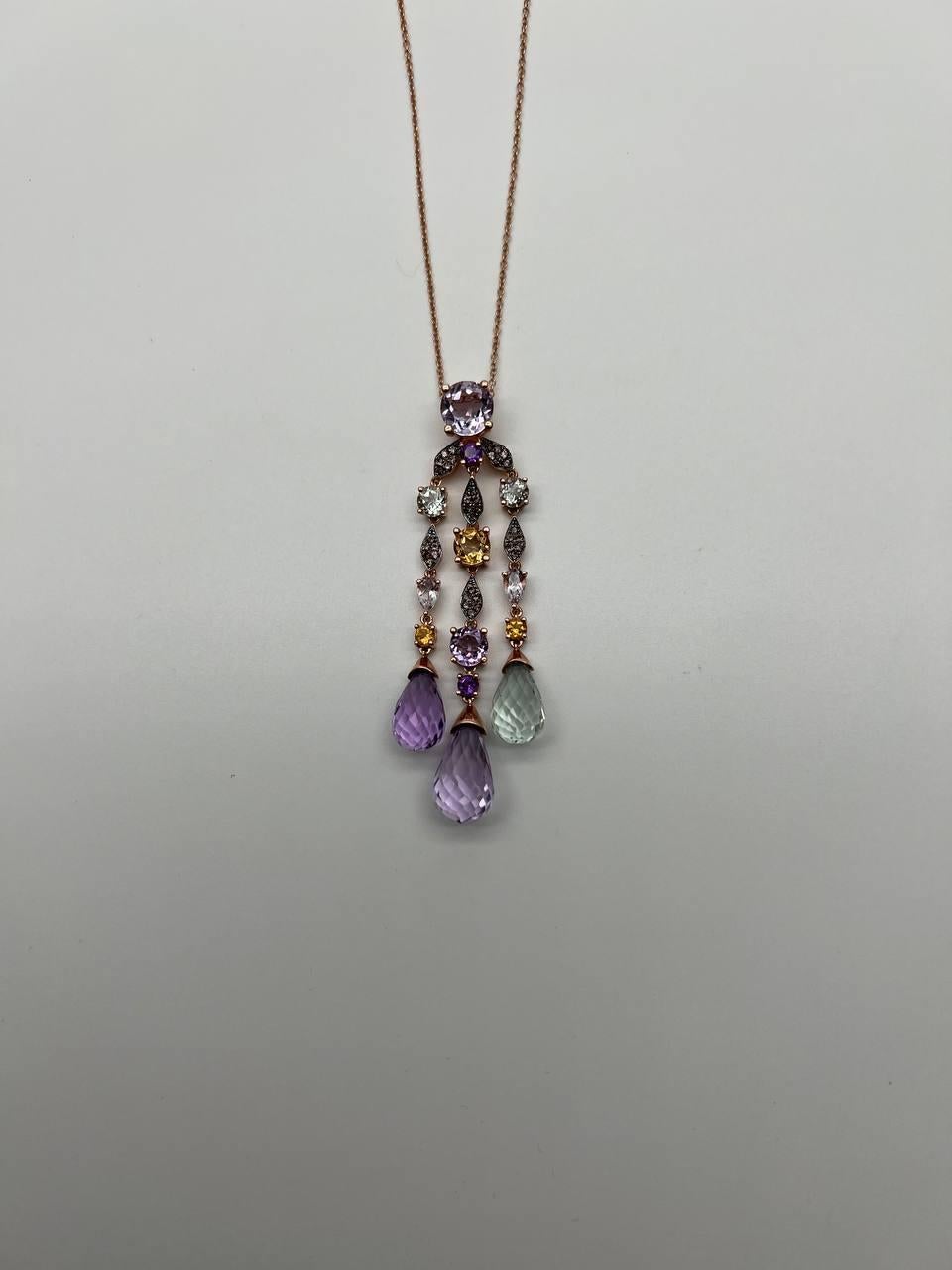 A stunning multicolored gemstone necklace. It features a series of faceted gemstones in various colors, including pink, green, and blue, arranged in an elegant cascading design. The centerpiece is a large round stone, complemented by smaller stones