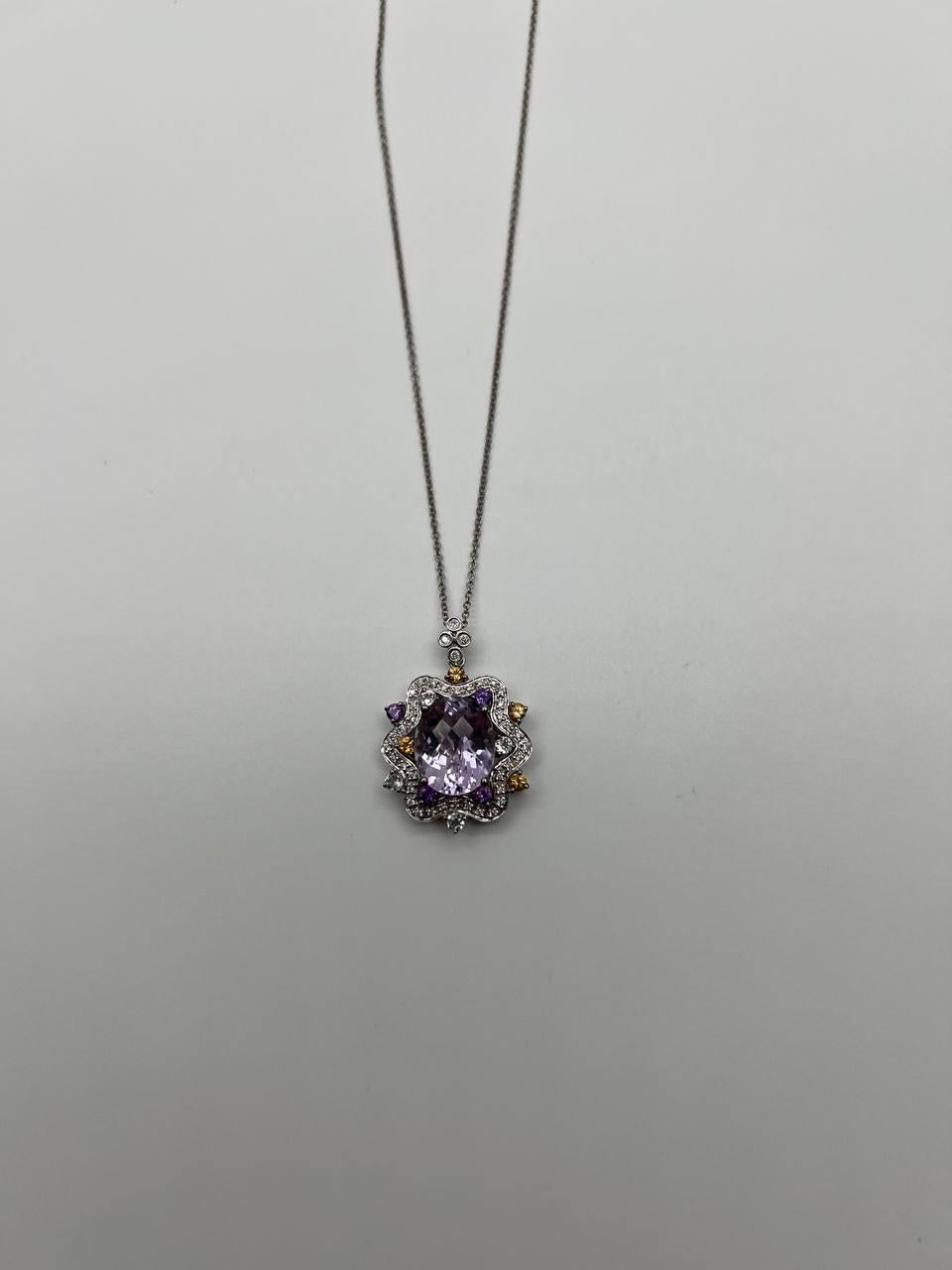 A captivating necklace featuring a pendant with a central violet amethyst, surrounded by a halo of multicolored semiprecious gemstones and white diamonds. The intricate design is set in a white gold with a delicate chain. 14K White Gold.
