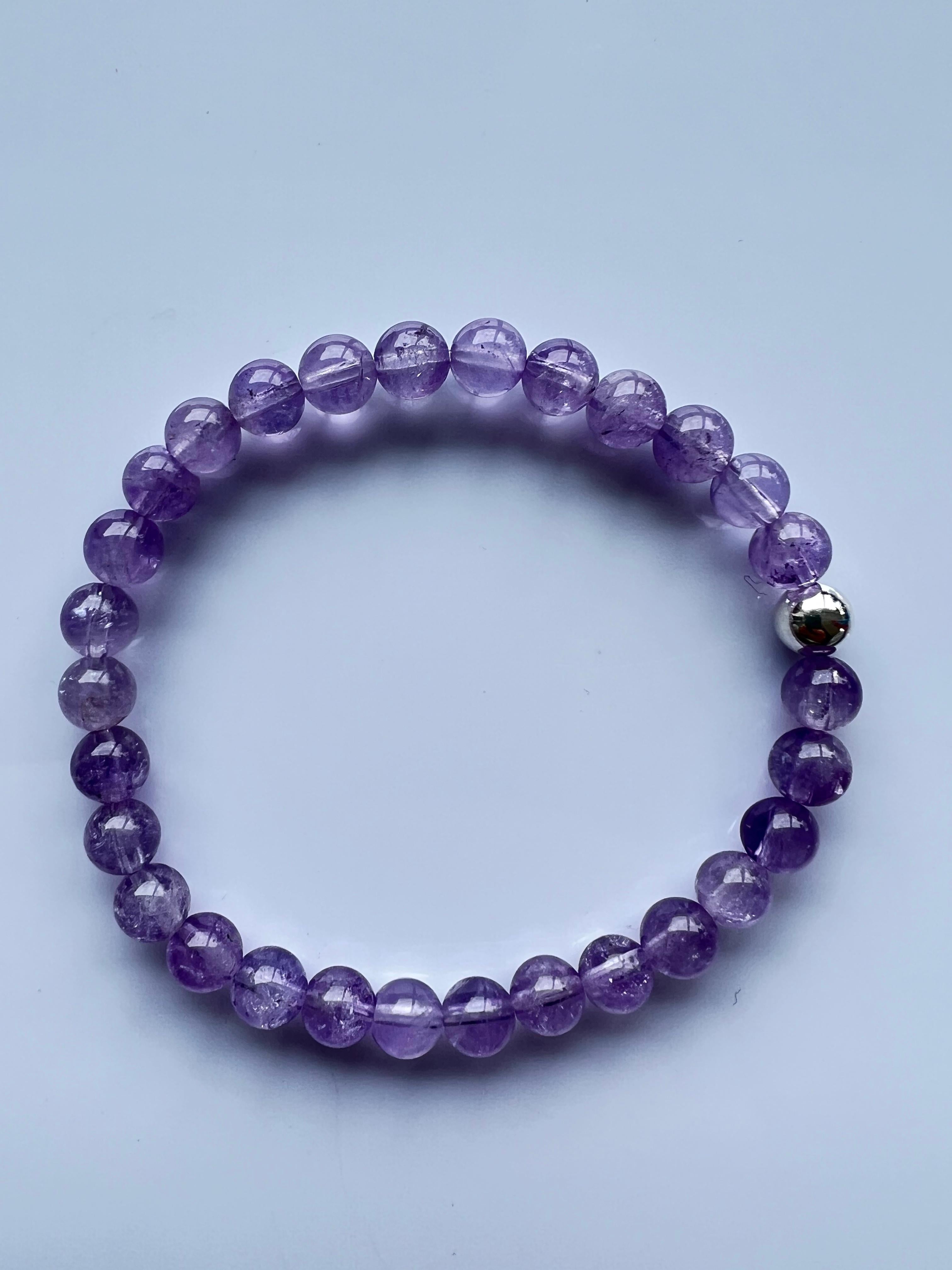 Violet Beaded Bracelet Natural Semi Precious Gem Crown Chakra Silver J Dauphin

Unveiling the J Dauphin Amethyst Beaded Bracelet, an exquisite piece of jewelry exuding a tranquil aura and deep spiritual symbolism. Each bracelet is meticulously