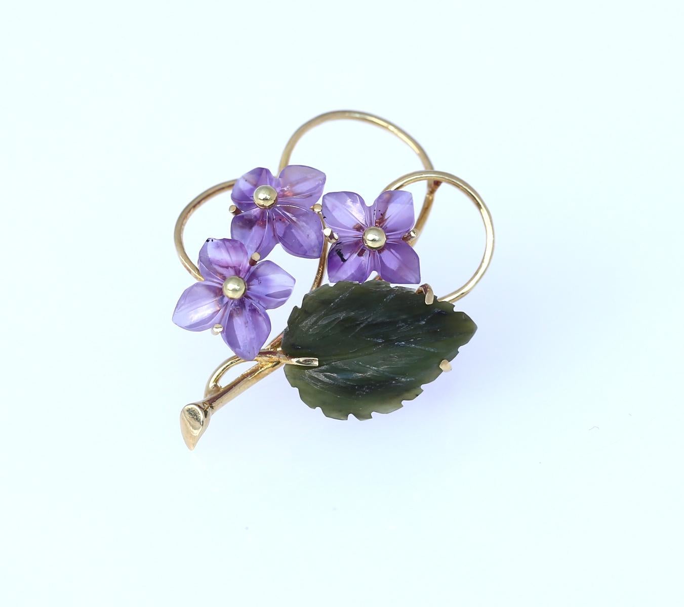 Violet flowers brooch comprising: Amethyst, Jade (jadeite). Yellow gold. Three engraved amethyst flowers with a green leaf made of jadeite. 

Once it was common to communicate a message via pin or brooch. Nowadays this art is lost, but we can surely