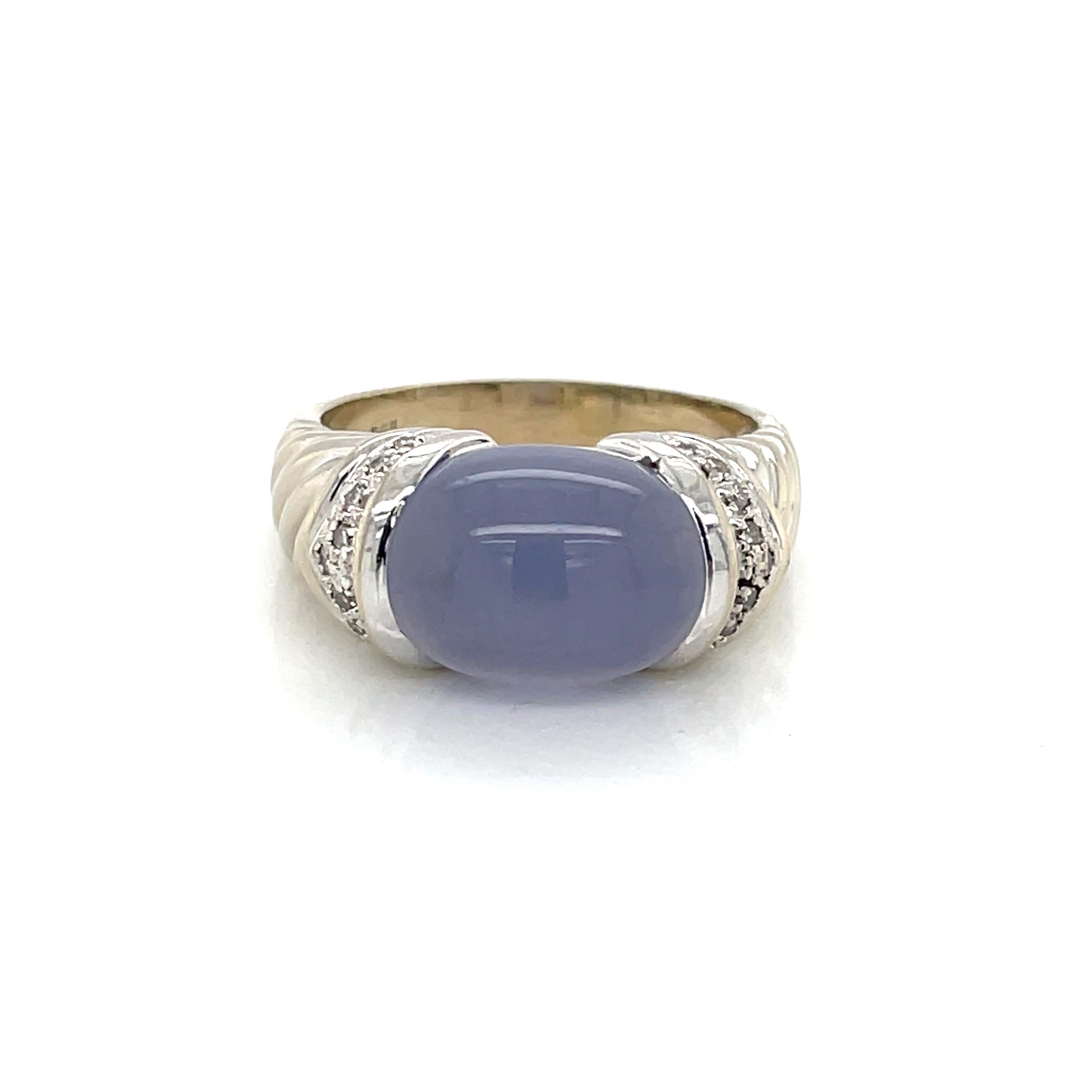 Hues of soft violet glow in chalcedony,  the feature of this dome style ring in fourteen karat 14K white gold. Diamond accents flank the soft colored stone and highlight the twist cable style ring shank as it graduates back. The gallery set oval