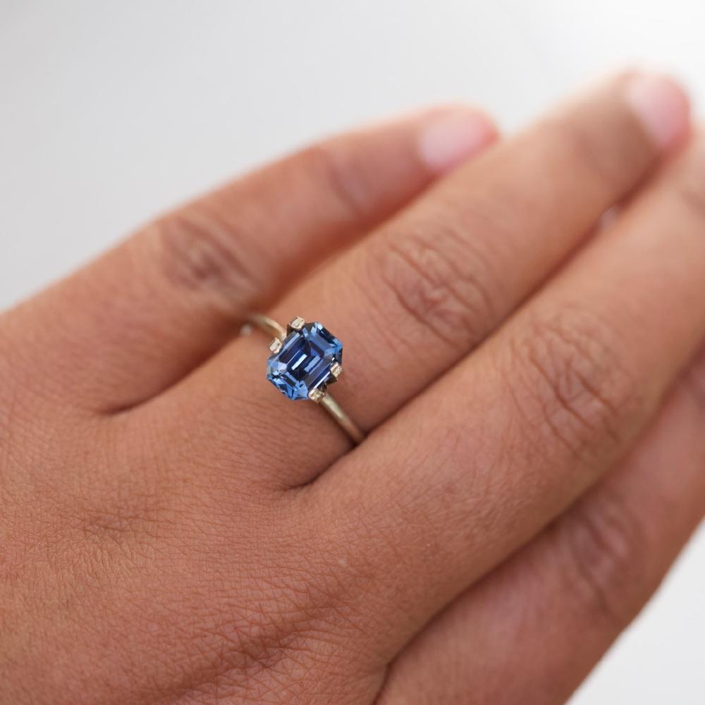 A steely blue sapphire with warm violet undertones in colour matches the remarkable durability of sapphires. Precisely emerald cut to over 2 carat using traditional skills, certified Sri Lankan and free of any heat treatments this violetish blue