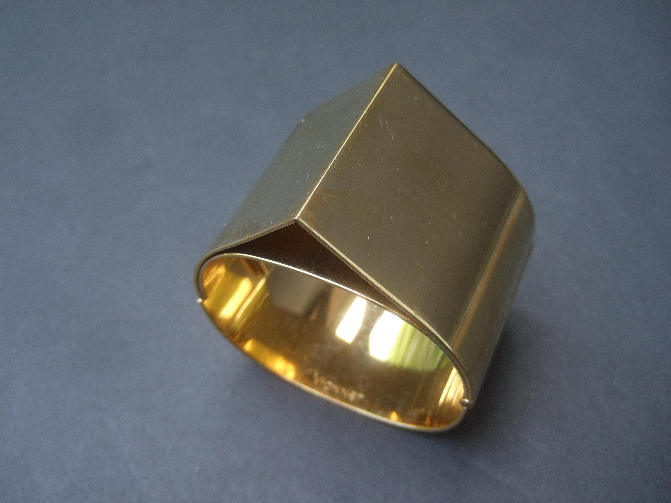 Vionnet Sleek wide gilt metal hinged cuff bracelet c 1990s
The bold severe wide cuff is designed with a triangular pyramid point that converges in the center

Makes a very chic eyecatching accessory 
The interior band is inscribed: Vionnet