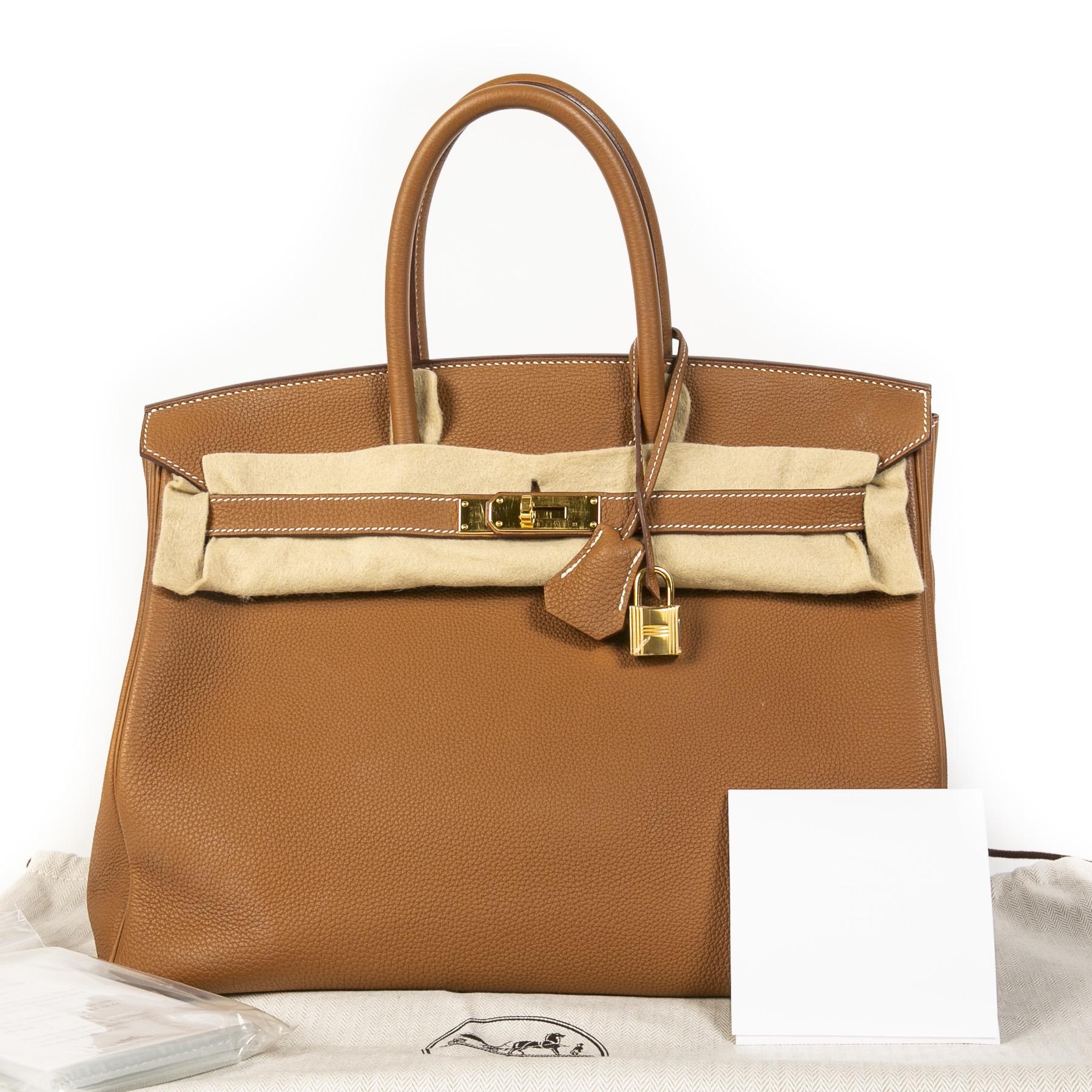 This rare and exclusive Hermès Birkin 35 Verso is crafted out of lovely pebbled Togo leather, a leather originating from baby calf. The outside of this Birkin comes in the timeless cognac 'Gold' color, the inside of the bag holds a surprise, as it