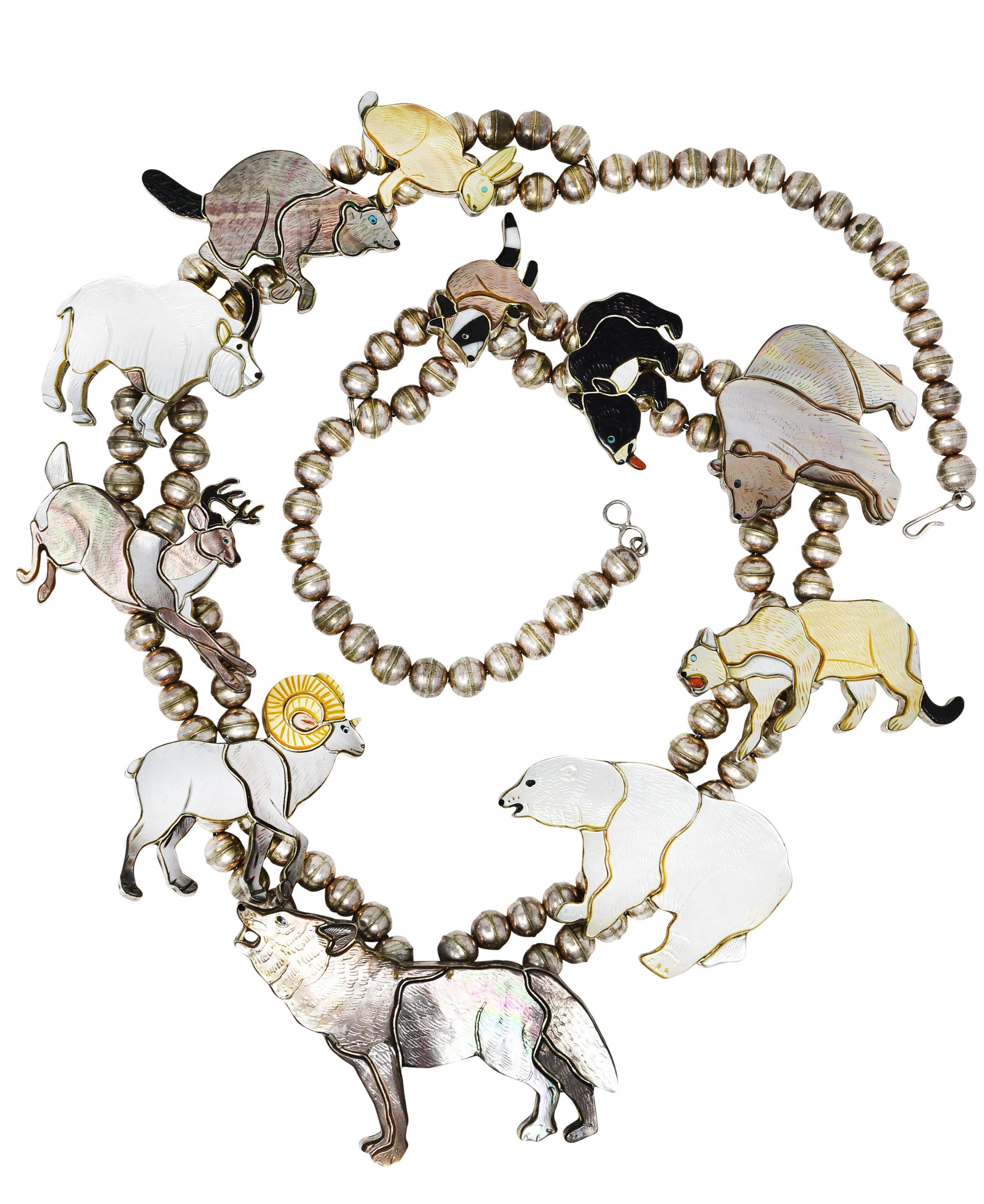 Necklace is designed as strands of round silver beads with large inlaid mother-of-pearl and shell animal stations
Engraved to depict a rabbit, beaver, goat, deer, ram, wolf, polar bear, cougar, brown bear, sun bear and racoon 
Mother-of-pearl and