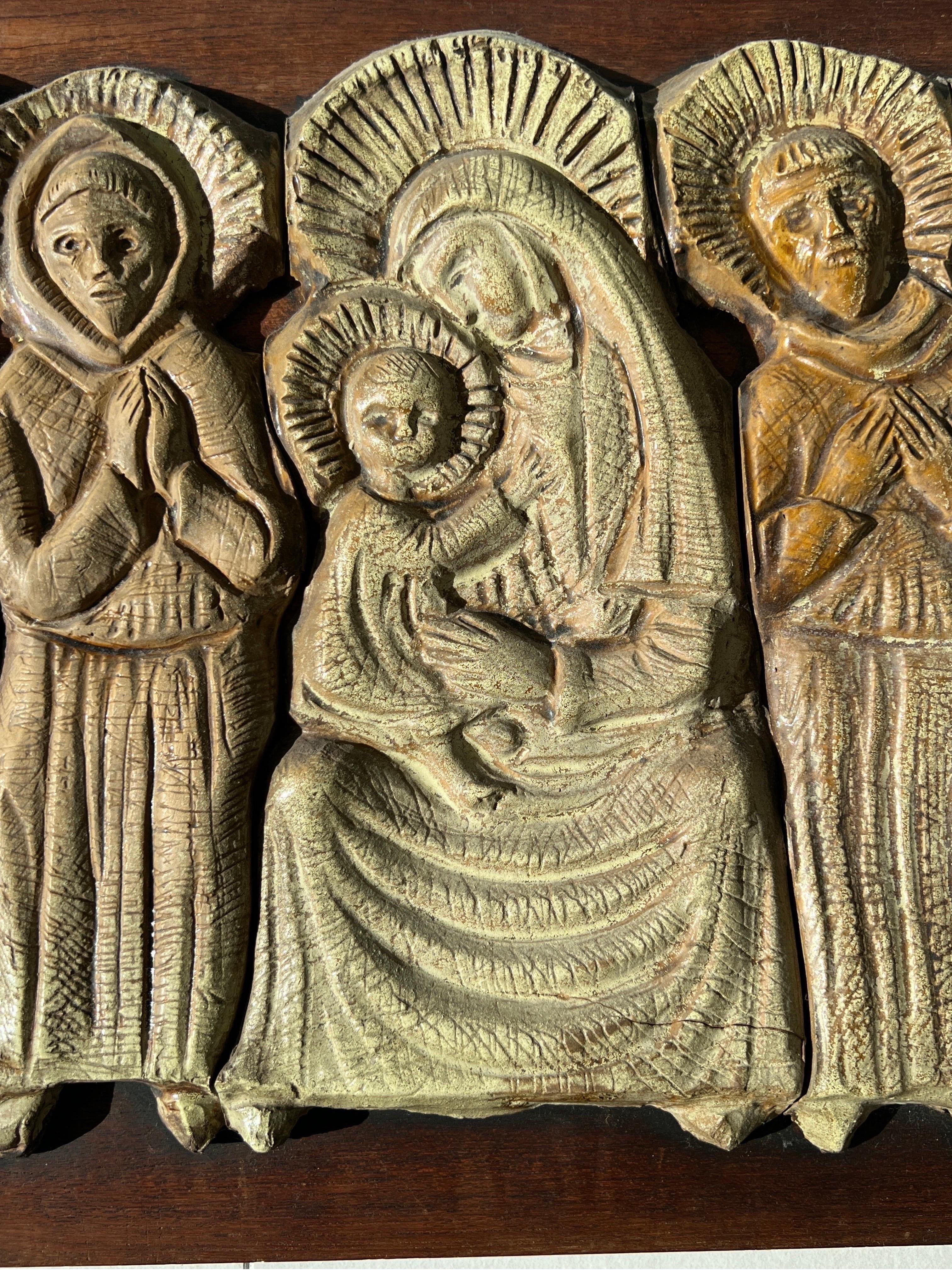 Bas-relief artisanal de 1960 italien, Marie tenant l'enfant Jésus accompagné de 6 saints, réalisé en résine sur panneau de bois.