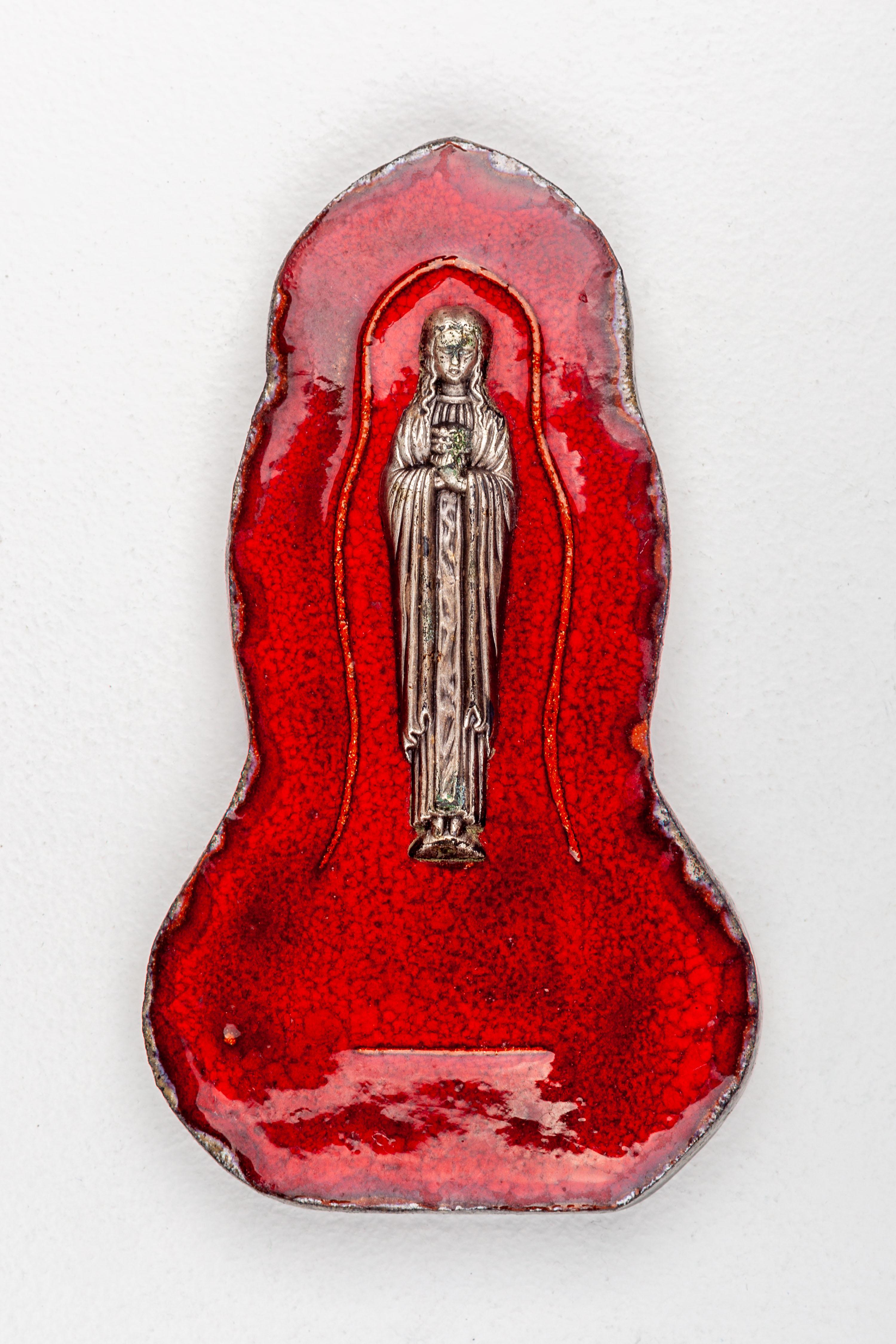 This captivating ceramic wall sculpture of the Virgin Mary epitomizes the ingenuity of mid-century European studio pottery. Handcrafted by an anonymous artist, this devotional artwork is steeped in the traditional Marian iconography yet is
