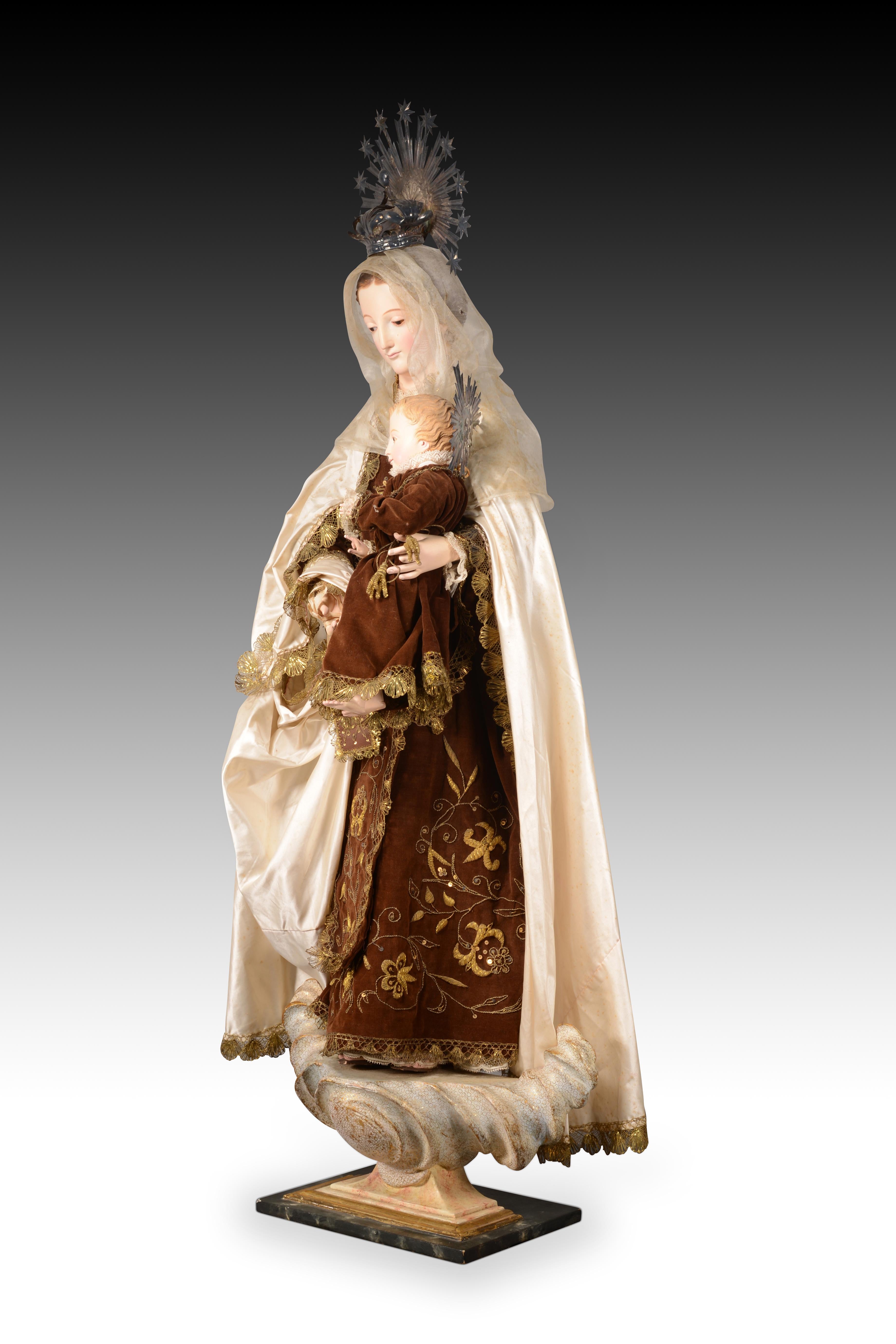 Virgen del Carmen para vestir. Madera, metal y textil. Spanish School del siglo XIX. 
Virgen del Carmen tallada en madera y policromada, imagen de vestir ricamente ataviada con una túnica bordada en oro con cuello de encaje blanco, un manto blanco