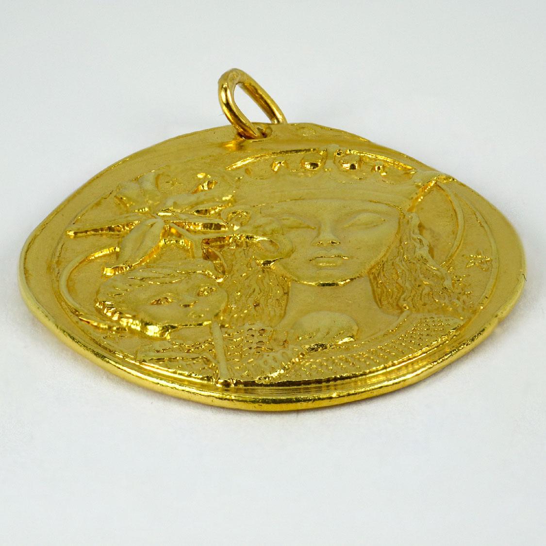 An 18 karat (18K) yellow gold pendant designed as a medal depicting the Madonna and Child with lilies. The reverse depicting a cross. Stamped with the owl for 18 karat gold and French import with unknown makers mark. 

Dimensions: 3.2  x 3.1 x 0.2