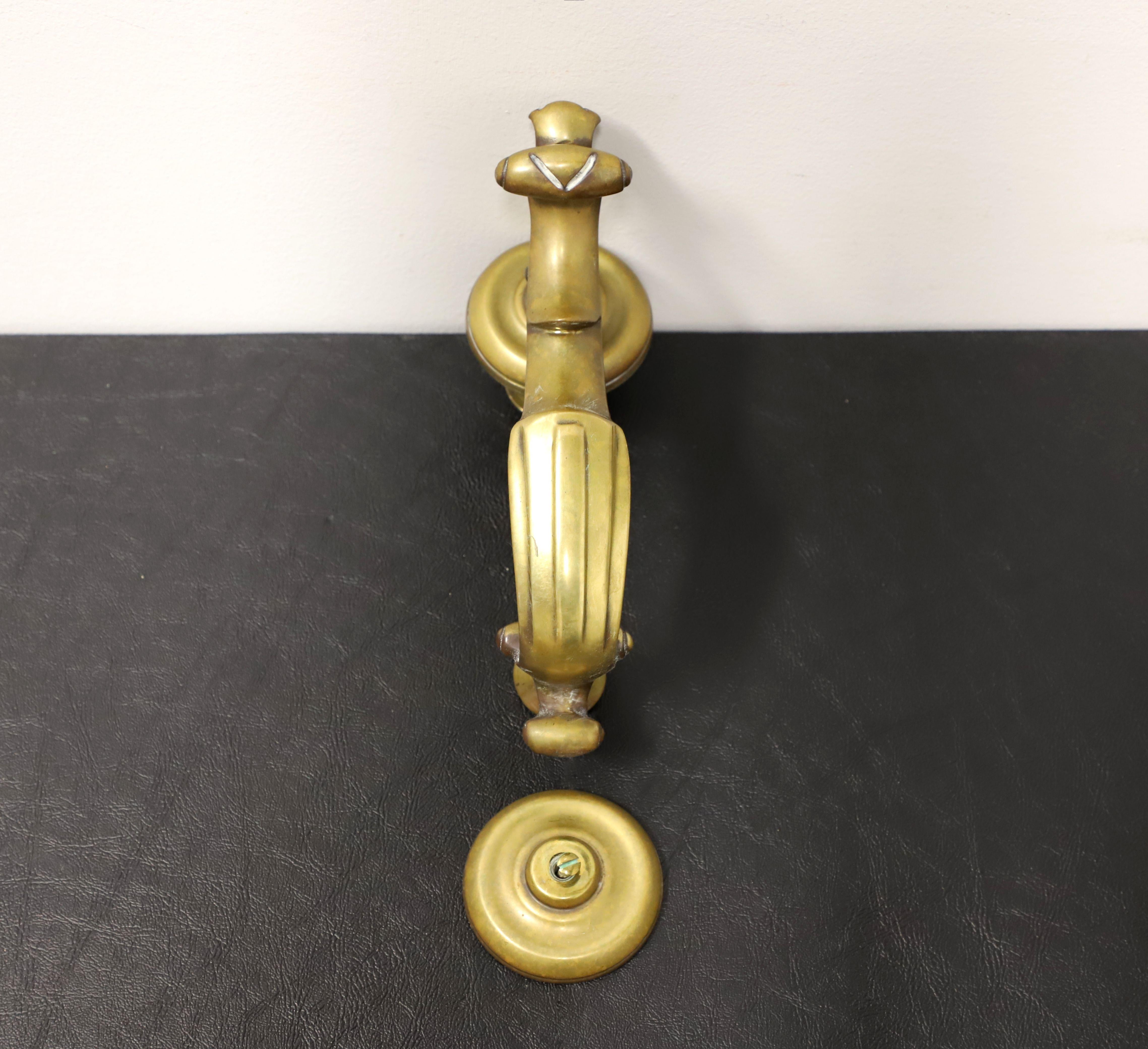 A door knocker and plate by Virginia Metalcrafters. Solid brass in a classic design. Includes bolt and screw for mounting to door for each piece. Made in Virginia, USA, in the late 20th Century.

Measures: Knocker:  2.75w 5.75d 8.5h, Plate: 2.75w
