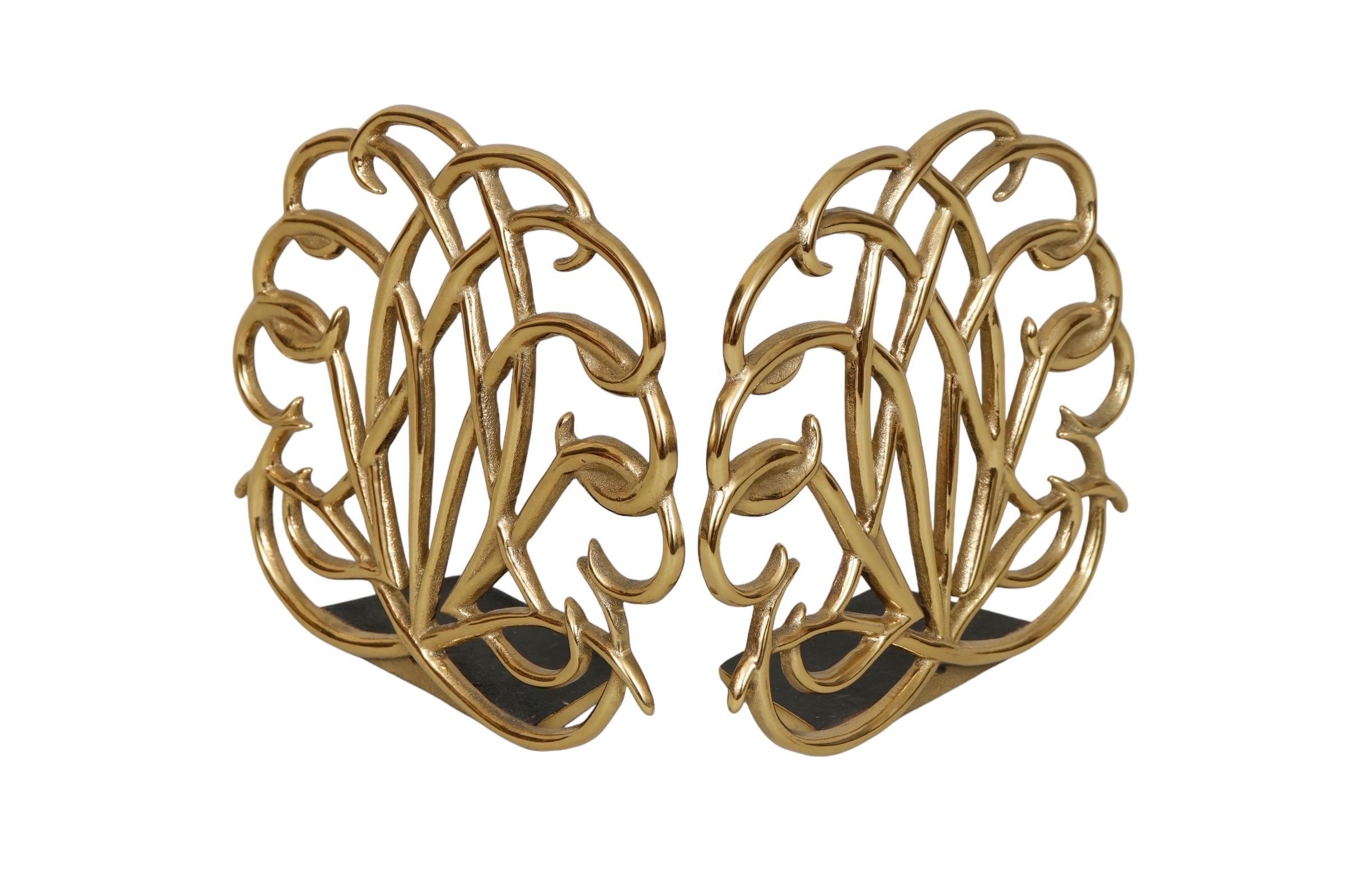 A pair of scrolled brass bookends made by Virginia Metalcrafters for their 2001 Williamsburg collection. The bookends are cast with a fan of c scrolls, and marked in the back with the manufacturer name and the date. Dimensions per bookend.
