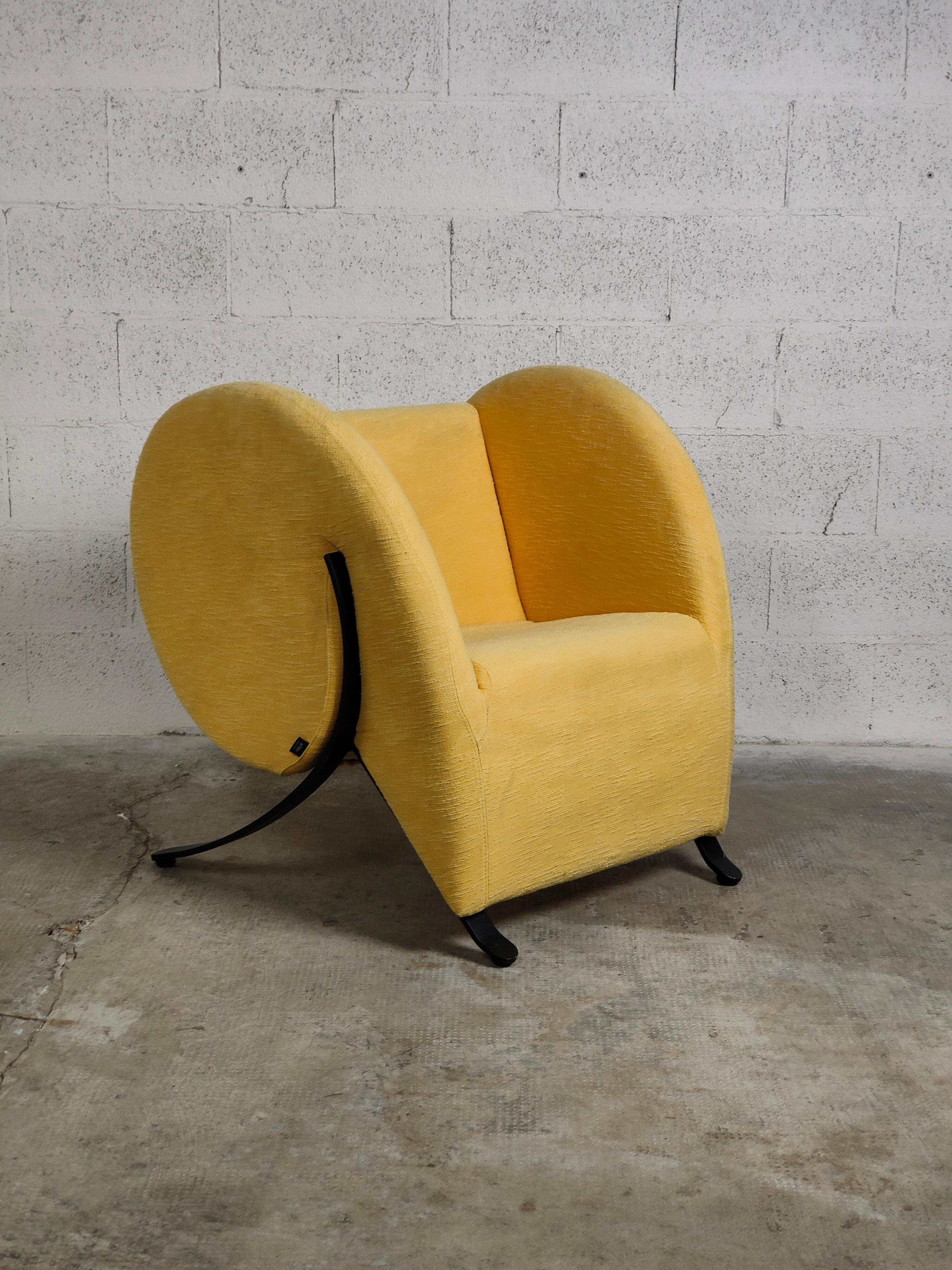 The Virgola armchair, designed by Yaakov Kaufman for Arflex, has a steel frame with molded polyurethane padding and polyester fiber, springing on elastic straps, legs in aluminum or black painted steel and removable cover in fabric or fixed in