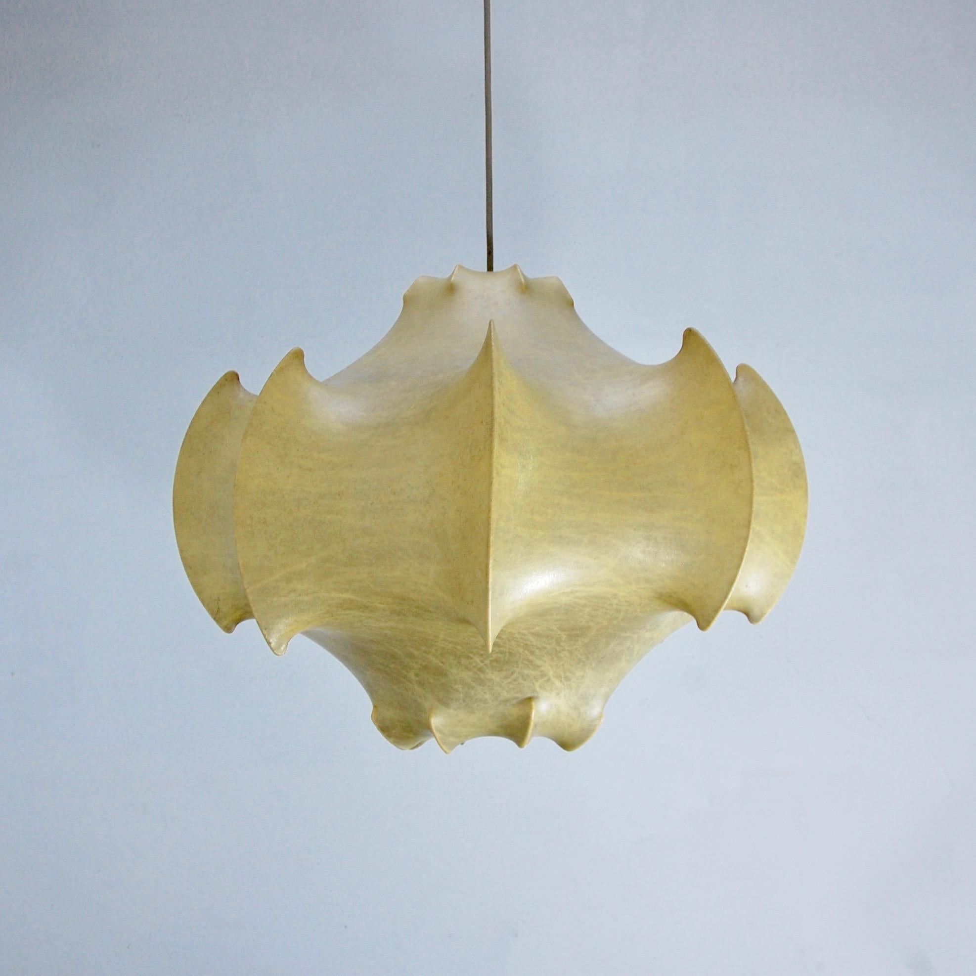 Unique glowing cocoon pendant from 1960s Italy by Achille and Pier Giacomo Castiglioni for Flos made in polymer, steel and brass. Partially restored. Wired for the US with a single E26 based socket. Light bulb included. Overall drop adjustable upon