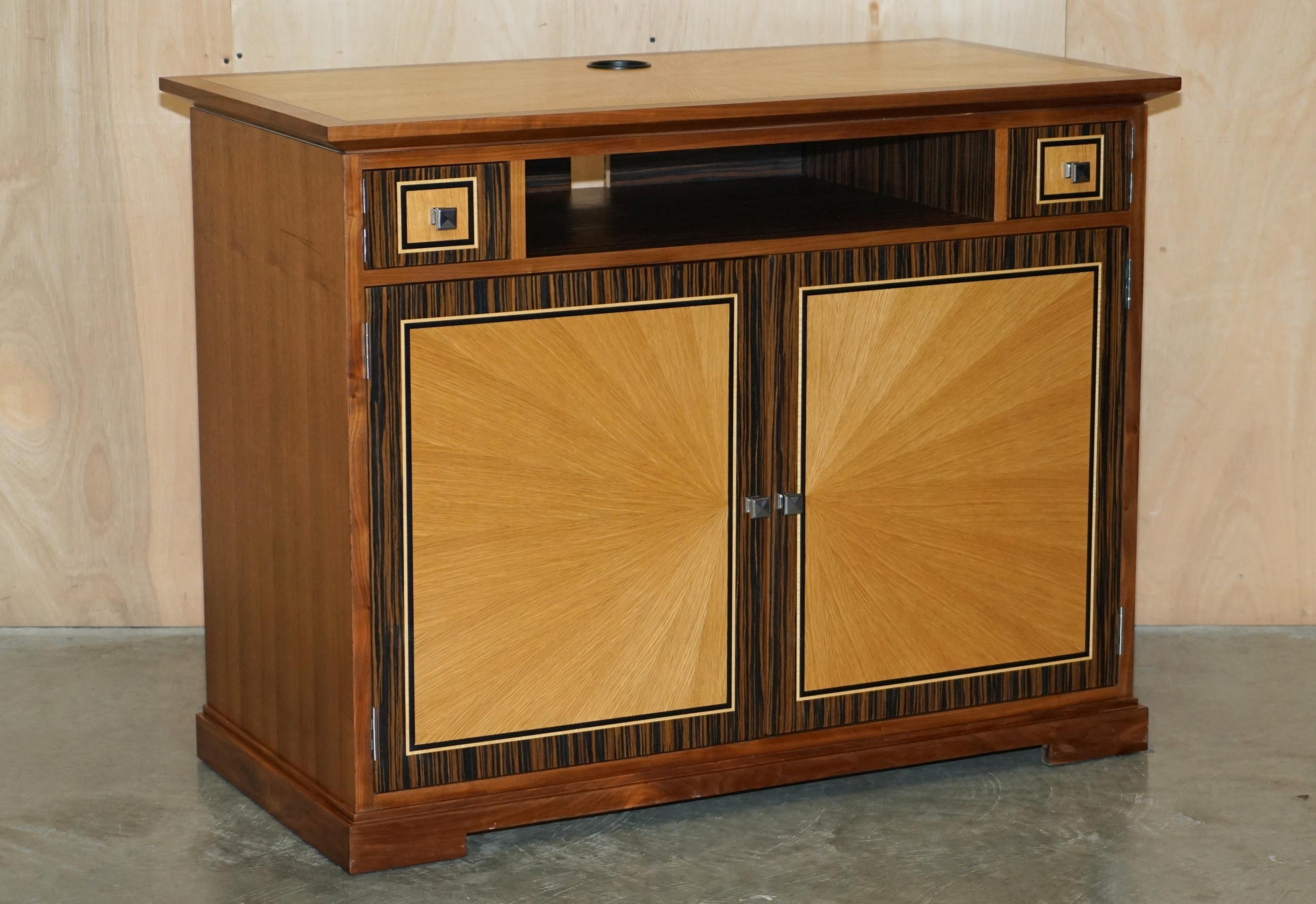 Royal House Antiques

Royal House Antiques is delighted to offer for sale this absolutely exquisite Viscount David Linley Satinwood & Macassar Ebony sideboard designed to seat a television and house media boxes

Please note the delivery fee listed
