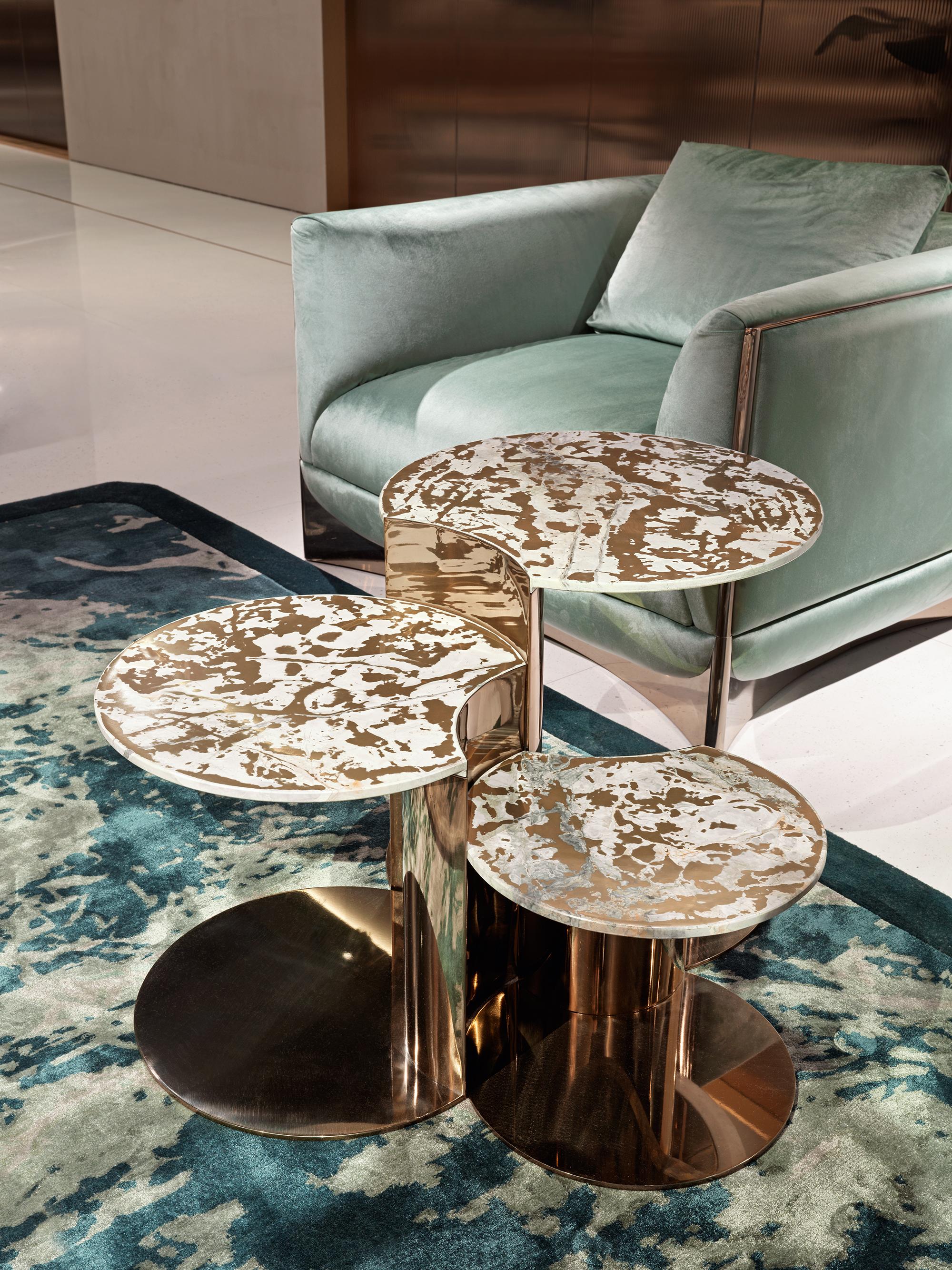 Set of 3 low tables in different sizes, structure in stainless steel with concave and convex shapes. Off-centre table leg in shiny steel with one concave side, terminating into the top with a concave curve. Top in polished marble with bevelled lower
