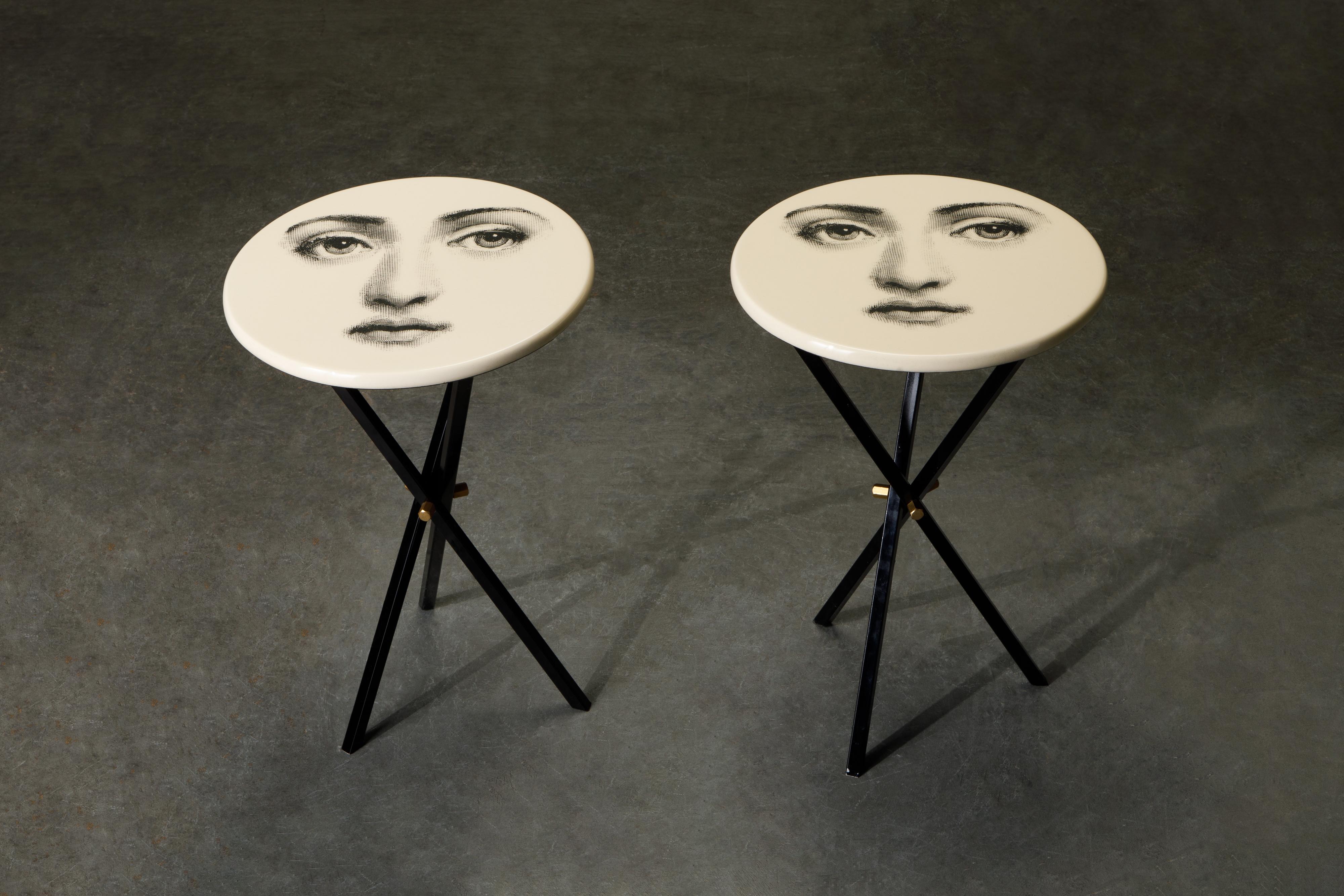 This fun and whimsical collectors set are a pair of side tables by Piero Fornasetti, signed underneath with original labels. These side tables are affixed on top of black painted brass tri-pod bases which are removable for easy and economical