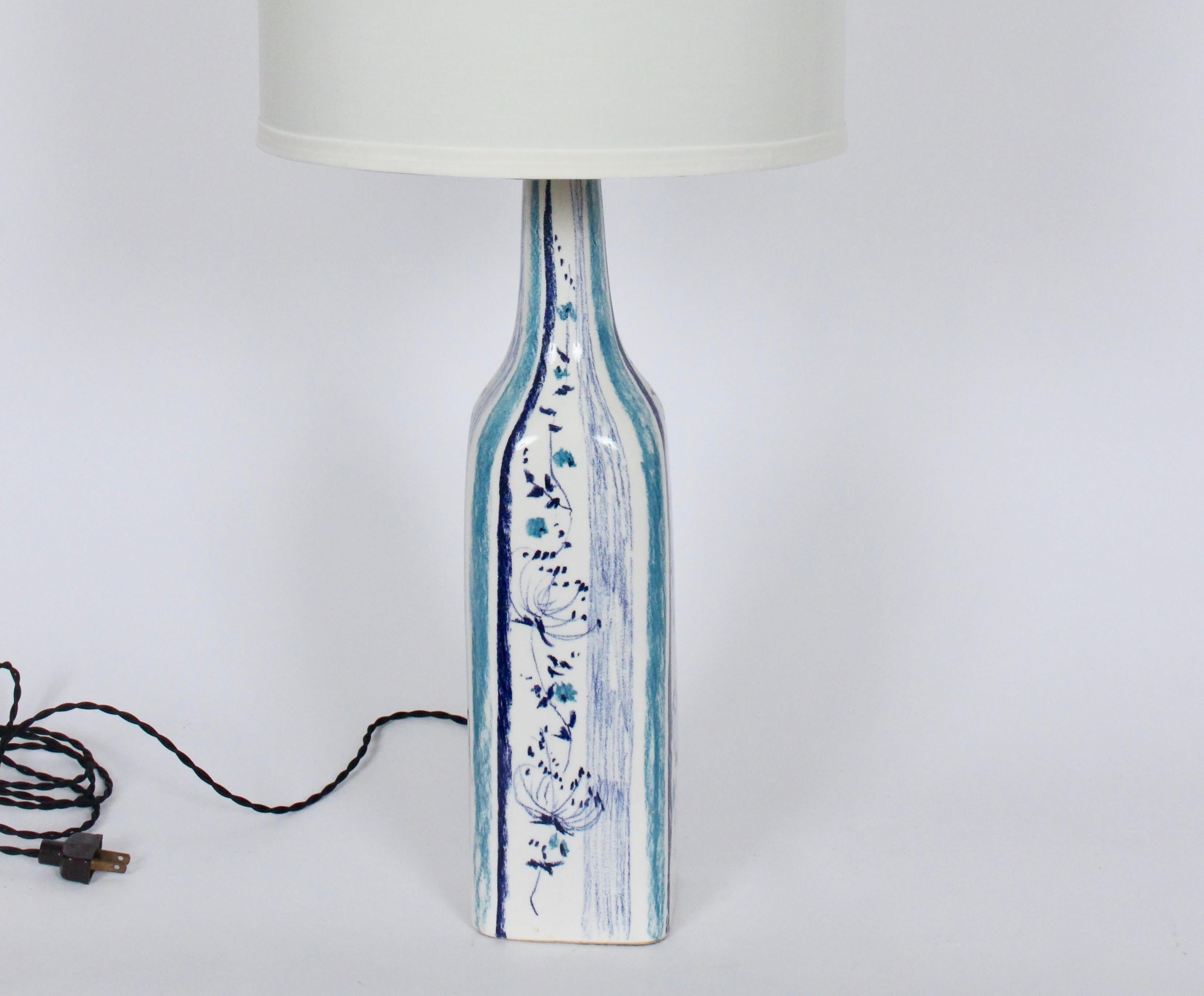Viso Italian Modern handcrafted blue, Turquoise glazed pottery table lamp. Featuring a bottle form delicately painted with Queens Anne Lace in hues of blue and detailed with Cerulean and navy blue vertical striping. Measures: 20H to top of socket.