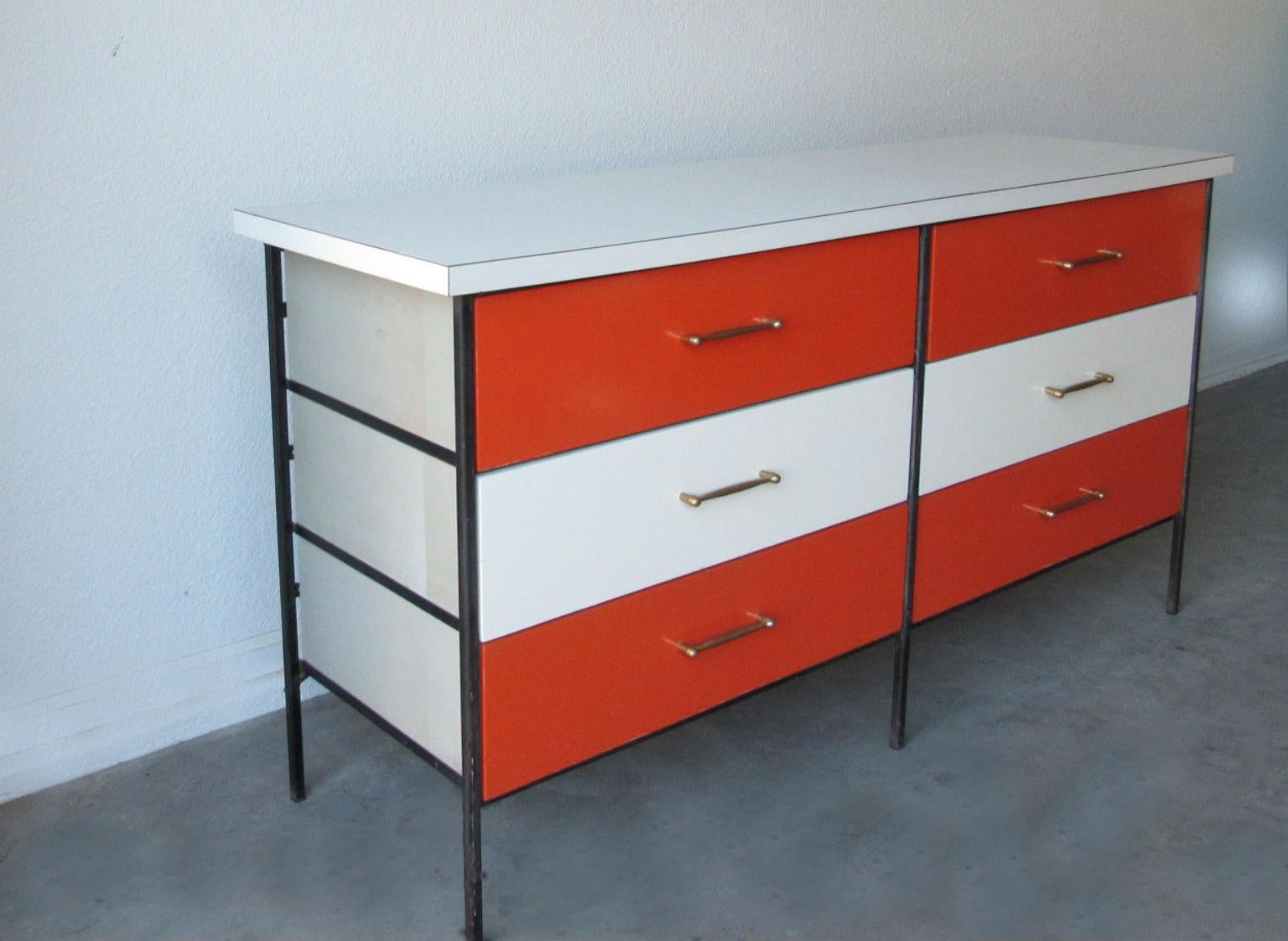 Chest of drawers by D.R. Bates and Jackson Gregory for Vista of California, 1950s. Wrought iron skeleton frame, multicolored drawer fronts in vivid orange and white, white laminate top and brass pulls. In very good original condition.
  