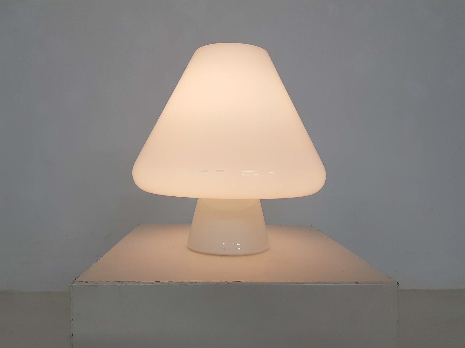 Glass mushroom shaped table, desk or floor lamp in the style of Vistosi and Venini Murano, dated 1960s.

Lamp is made of beautiful opaline glass, which gives a nice glow when switched on. We haven't found its maker yet, but the light has many