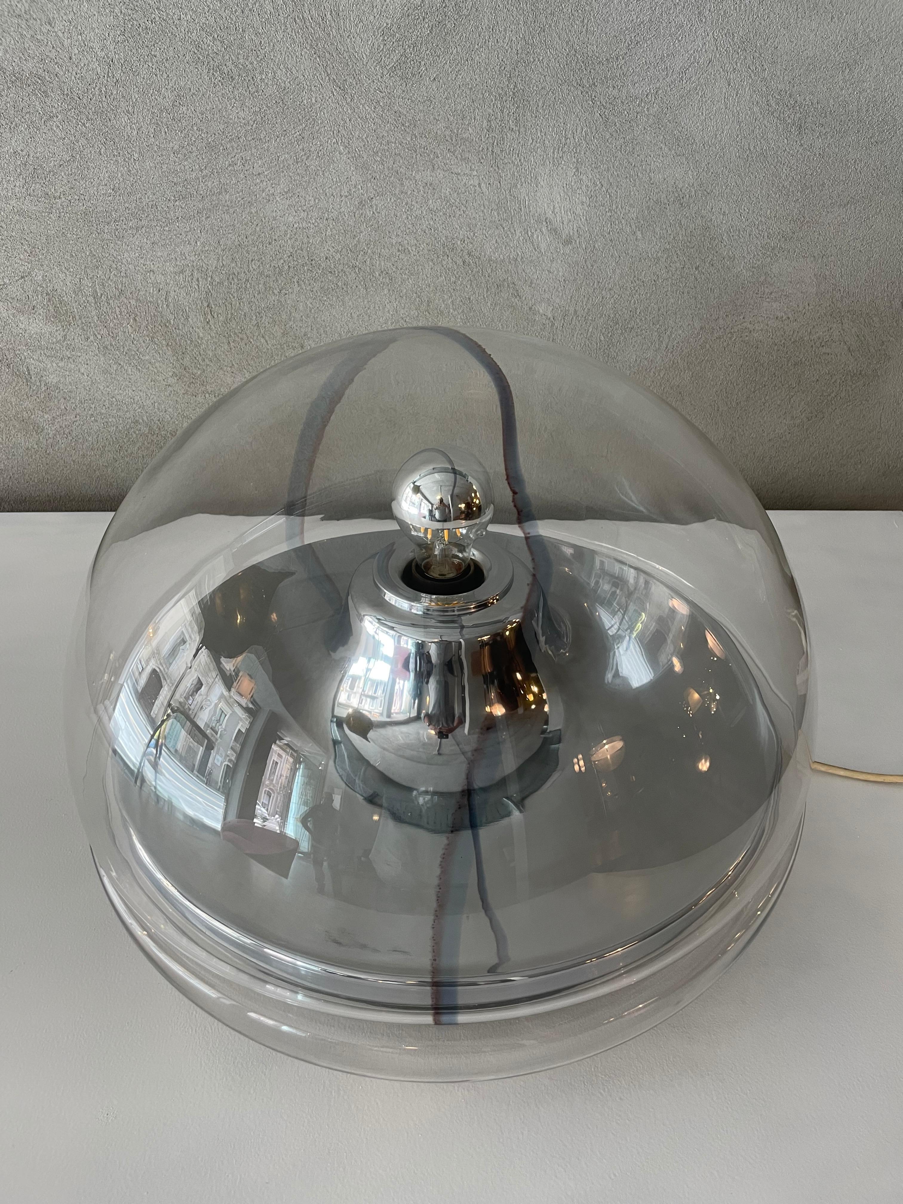 Murano glass table lamp by Vistosi Italy, 1970.
The lamp has a spherical shape and inside it has a chrome plating, and a black band at the base.
The electrical system is original.

Vistosi has managed to establish itself in the world of