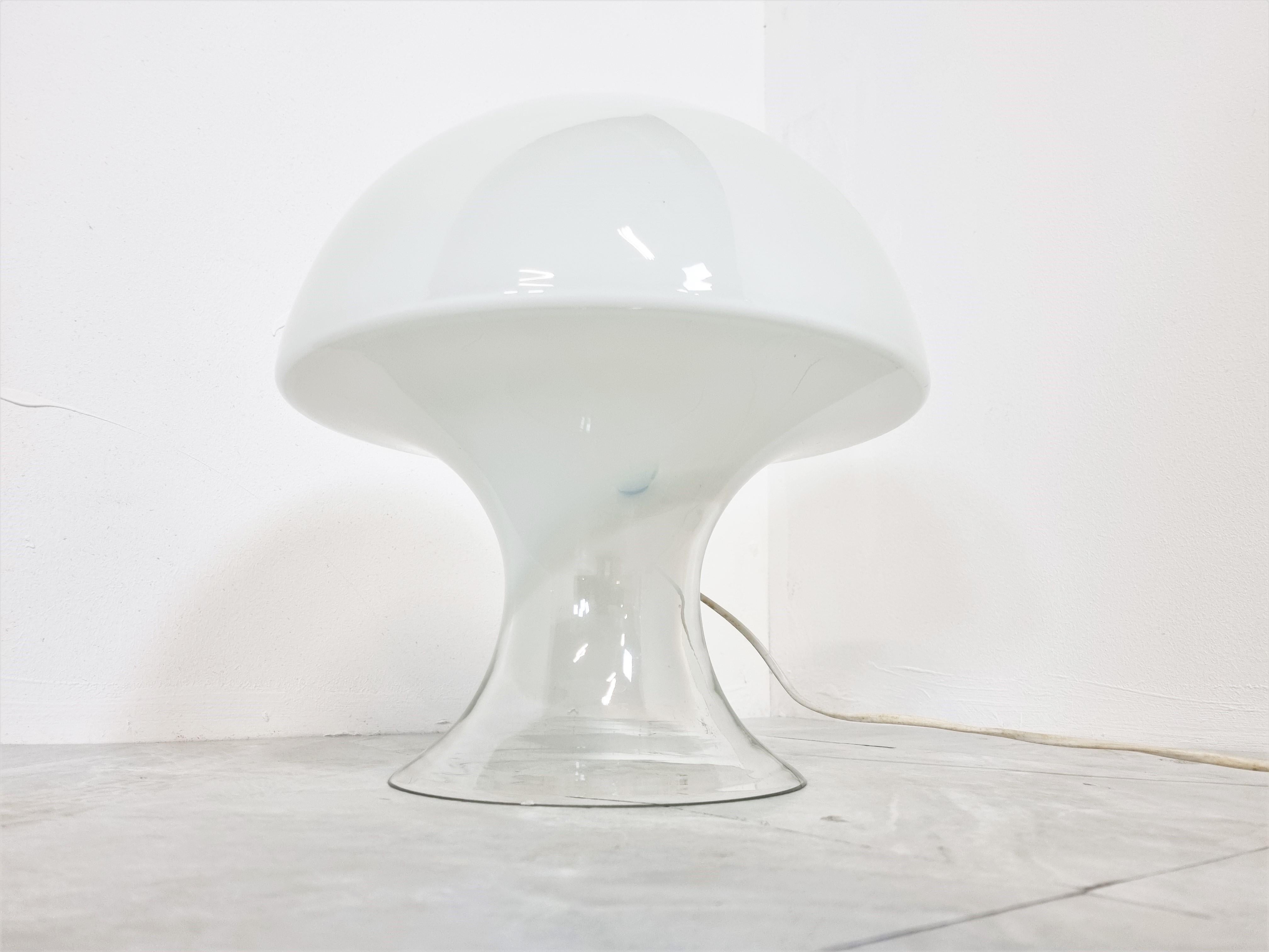 Mid century white opal hand blown murano glass table lamp.

This 'mushroom' table lamp emits a beautiful light and has a clear glass base and then a more white opal effect towards the top.

Designed by Enrico Capuzzo

1960s - Italy

Good