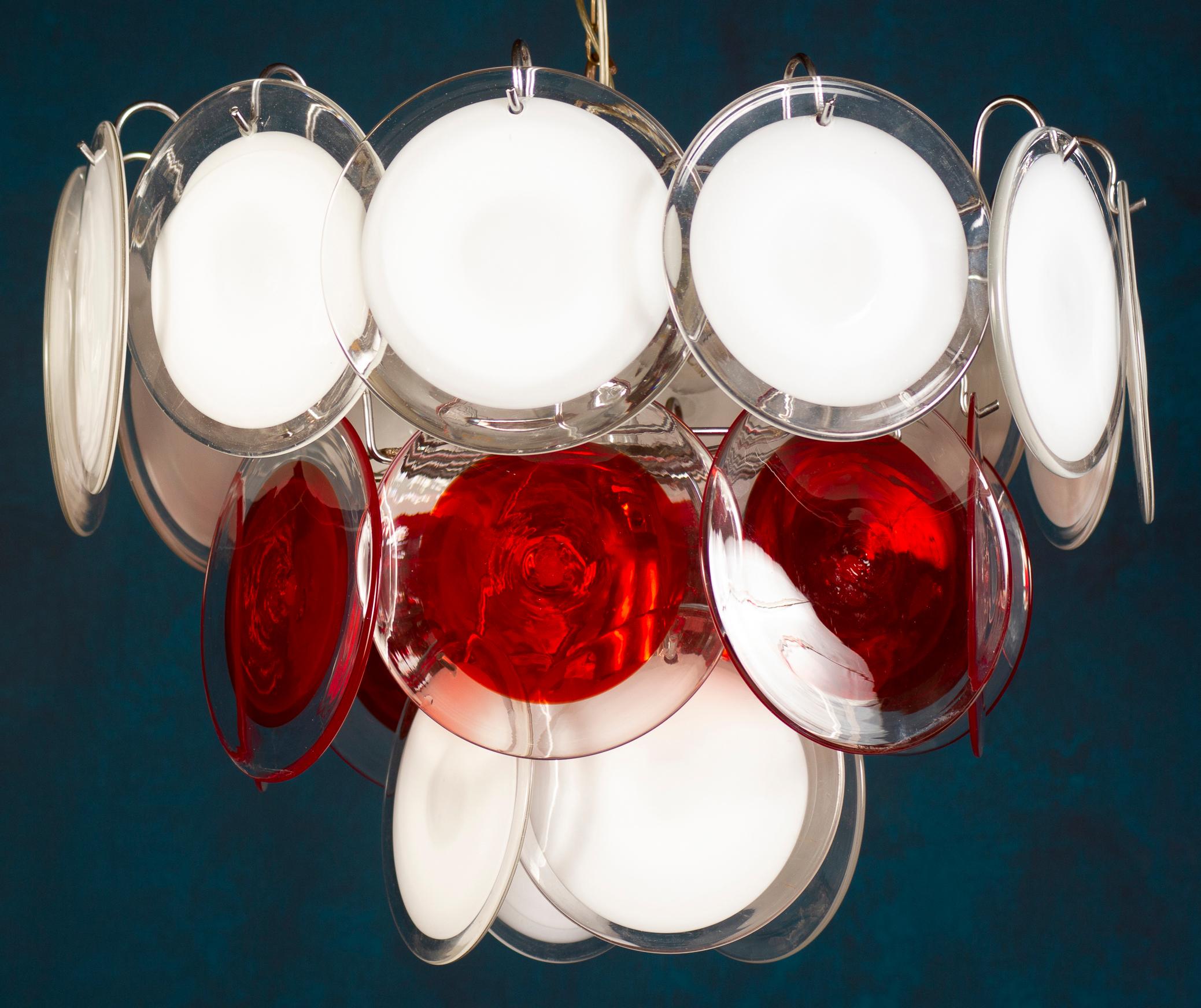 The 24 white and red discs of precious Murano glass are arranged on three levels. 
Nine E 14 light bulbs. Height without chain 40 cm.
Available also a pair.