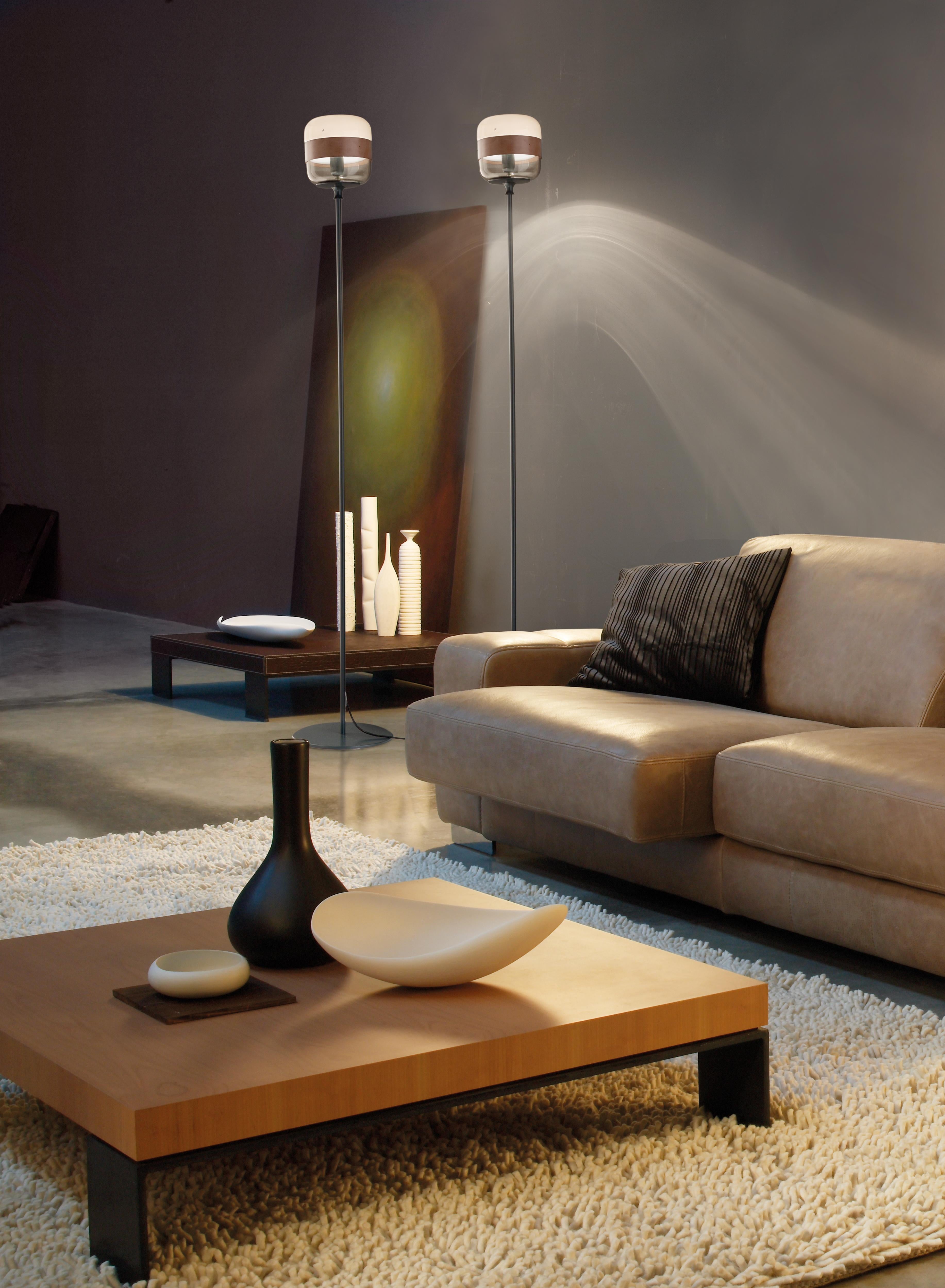 Collezione di lampade in vetro soffiato disponibili in colori trasparenti e tre colori esclusivi abbinati a diverse finiture dell'anello metallico. Il vetro è soffiato in un unico pezzo ma il particolare processo artigianale rende il colore