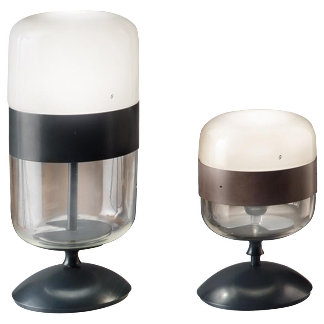 Collection of lamps in blown glass available in transparent and three exclusive colors combined with different finishes of the metal ring. The glass is blown in one piece but the particular handcraft process makes the color transparent in the upper