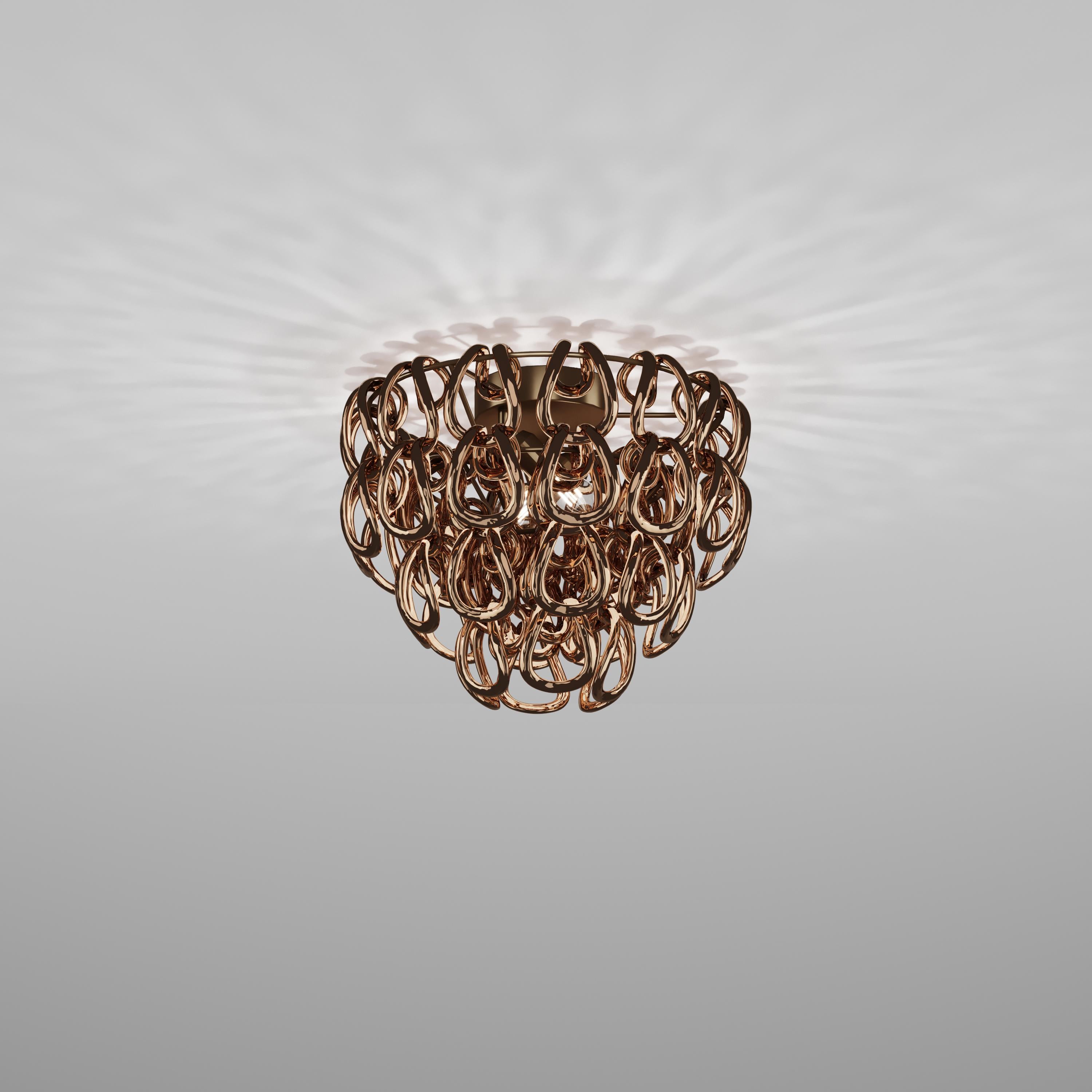 Un élément pur : le crochet en cristal. C'est l'intuition d'un maître du design italien, Angelo Mangiarotti, qui a créé en 1967 le best-seller du catalogue Vistosi, Giogali. Un entrelacement iconique appliqué à la version que l'on