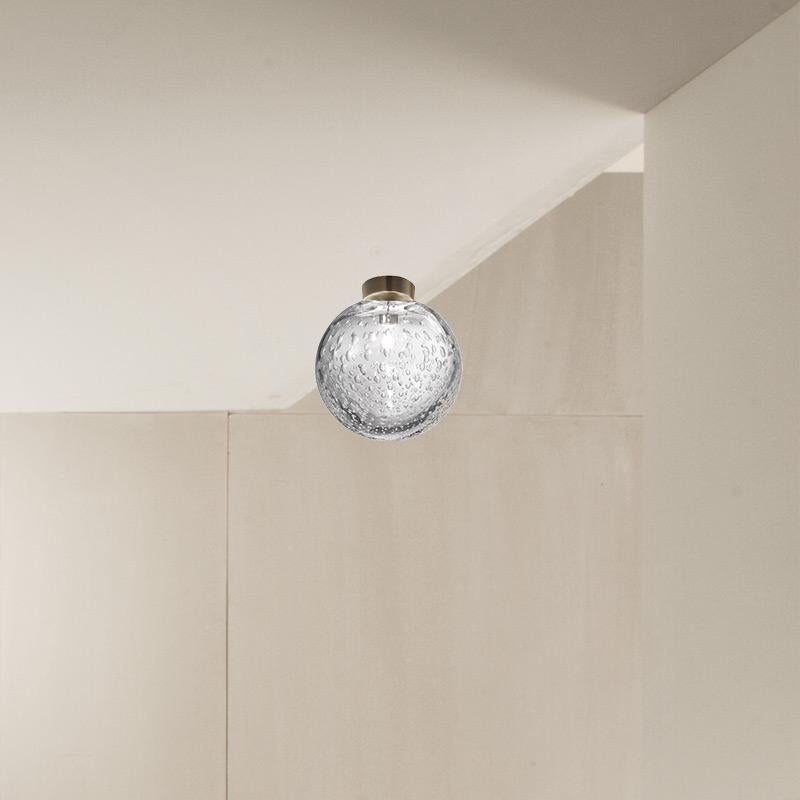 Das Hauptmerkmal dieser Lampenkollektion, die mit der Ballotontechnik hergestellt wird, ist das Einbringen von Luftblasen in das Glas während der Herstellung, die vielfältige Reflexionen erzeugen und der Oberfläche der Kugel eine organische Textur