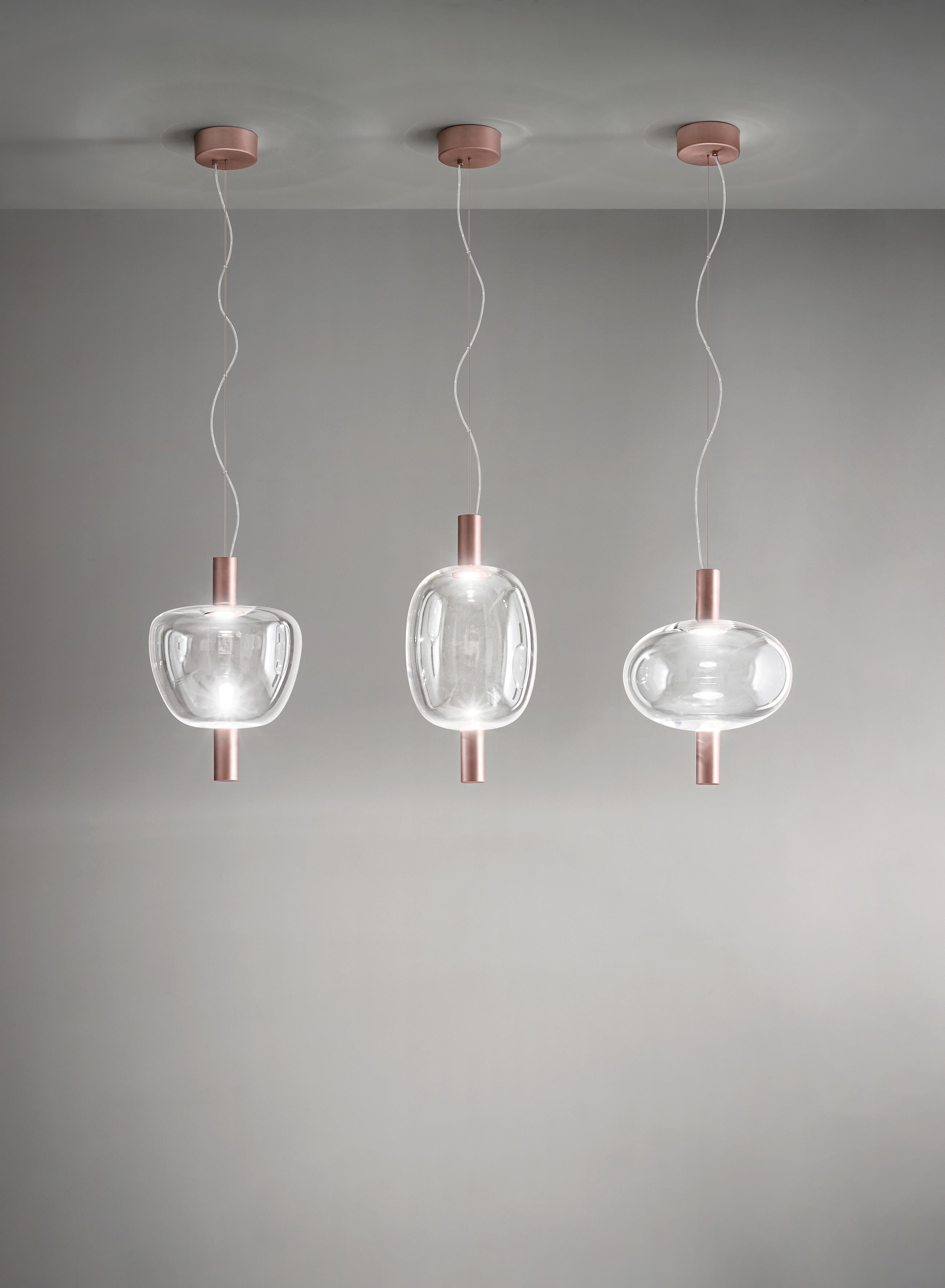 La luce LED passa attraverso una bolla di vetro e si rifrange su uno specchio in un gioco di rimbalzi continui. Il vetro non è solo un diffusore, ma anche un intermediario quasi invisibile tra la sorgente luminosa e l'elemento riflettente. La