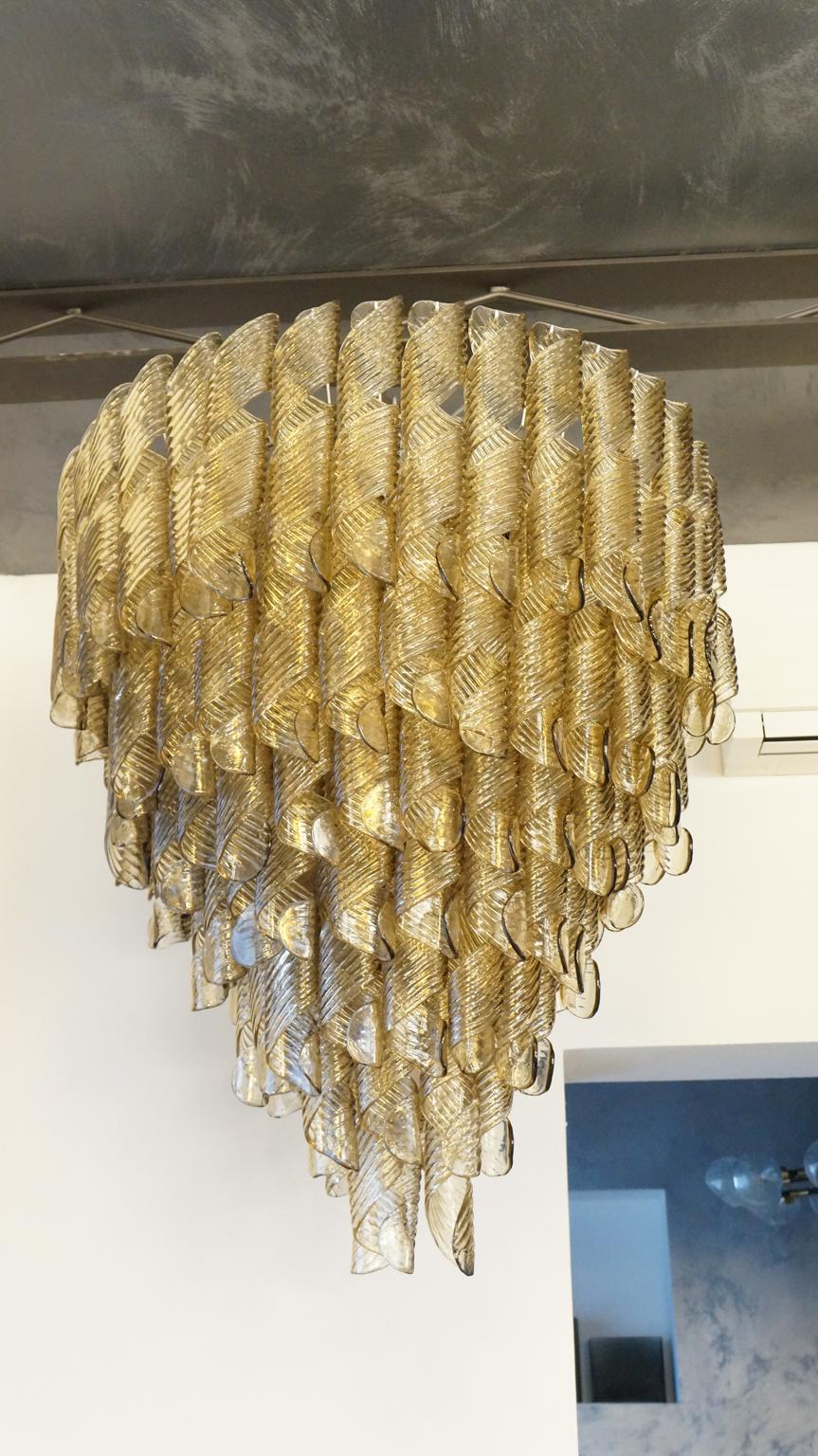 Designed in 1988 by Vistosi, this vintage chandelier consists of 134 Murano glass elements, which is certainly not a few number. Moreover, they feature this particular fume color, a rather elegant and fine shade of brown. It is adorned with 13 light